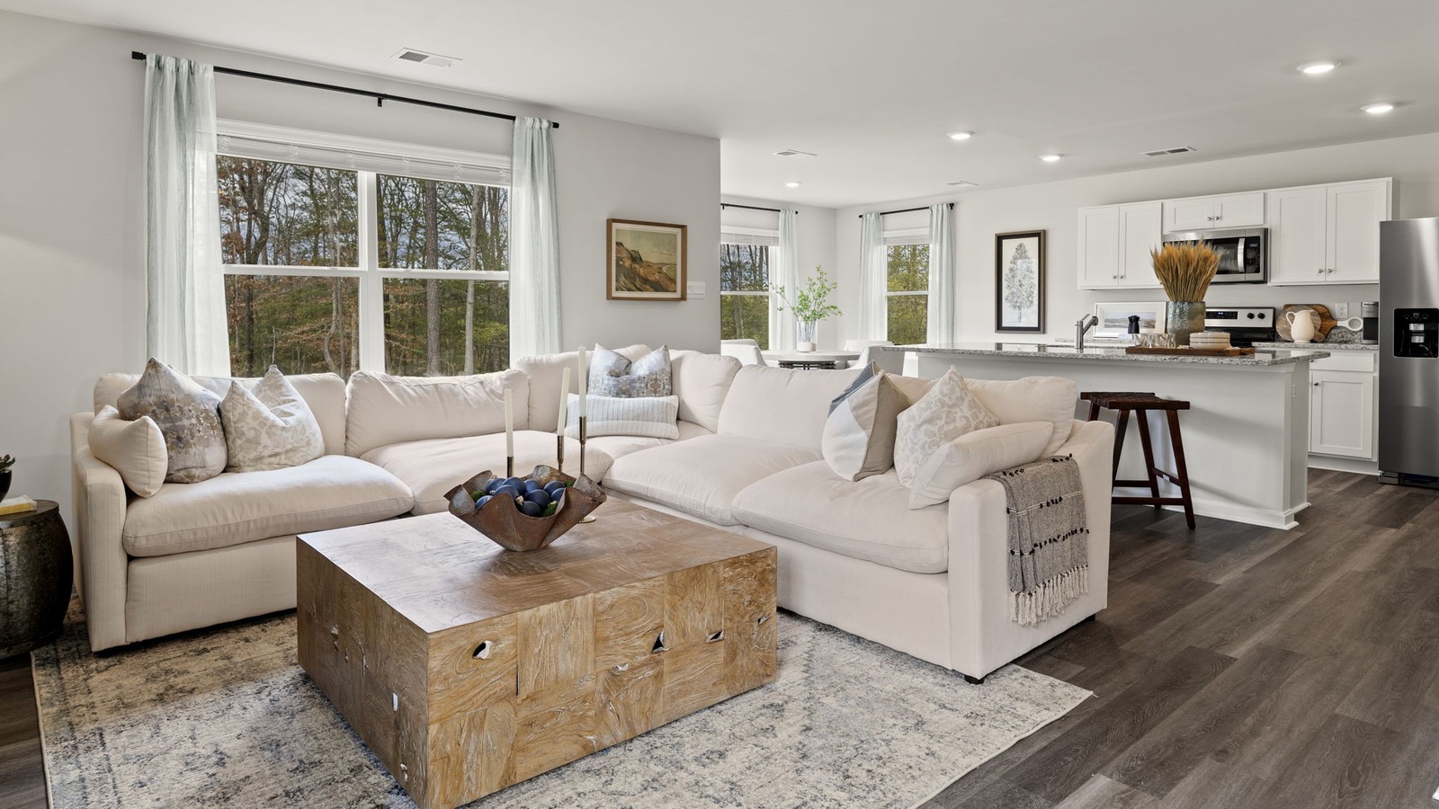 Main-level living room offers a bright space with electric fireplace and Open Concept connection to kitchen and living spaces