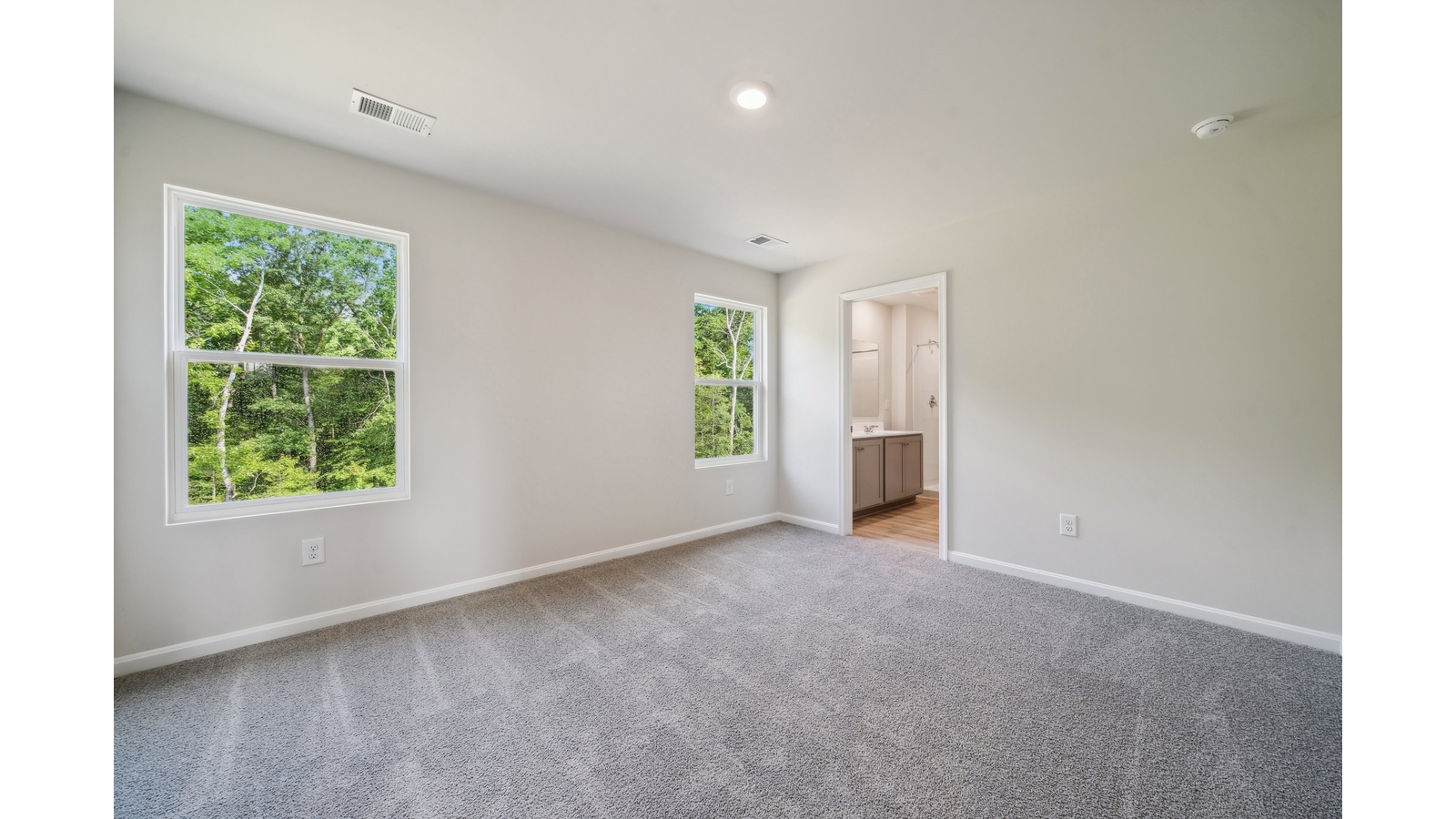 Primary bedroom designed for privacy and space with clean lines and a convenient flow into en-suite bathroom and walk-in closet