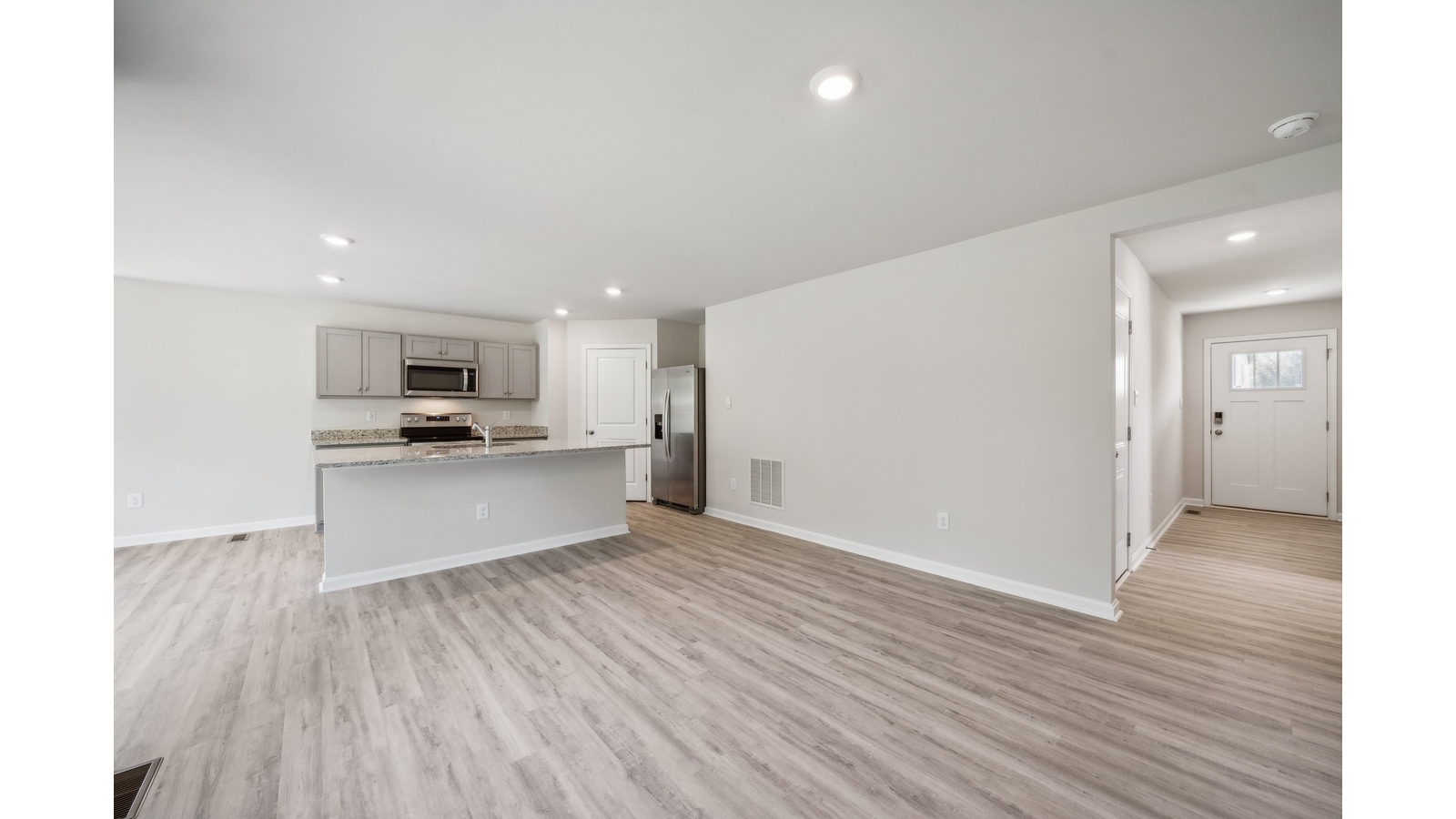 Living room, kitchen, and dining area function as one cohesive main space at Arbors at Farms of New Kent by D.R. Horton