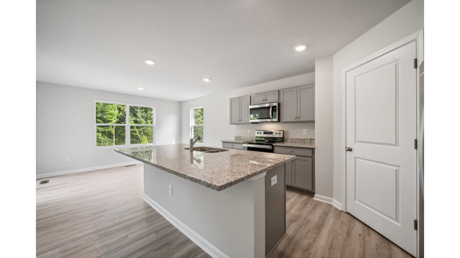 Main living space at Arbors at Farms of New Kent offering natural light and open layout between kitchen, dining-living room