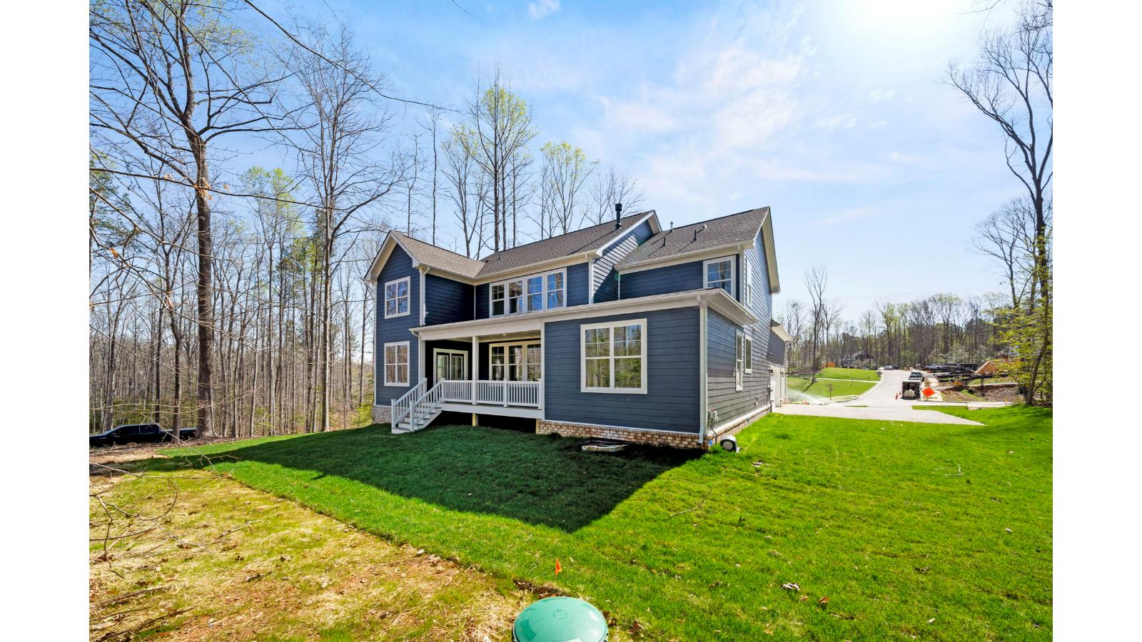 New build home with covered back deck by D.R. Horton featuring grass lawn, large backyard