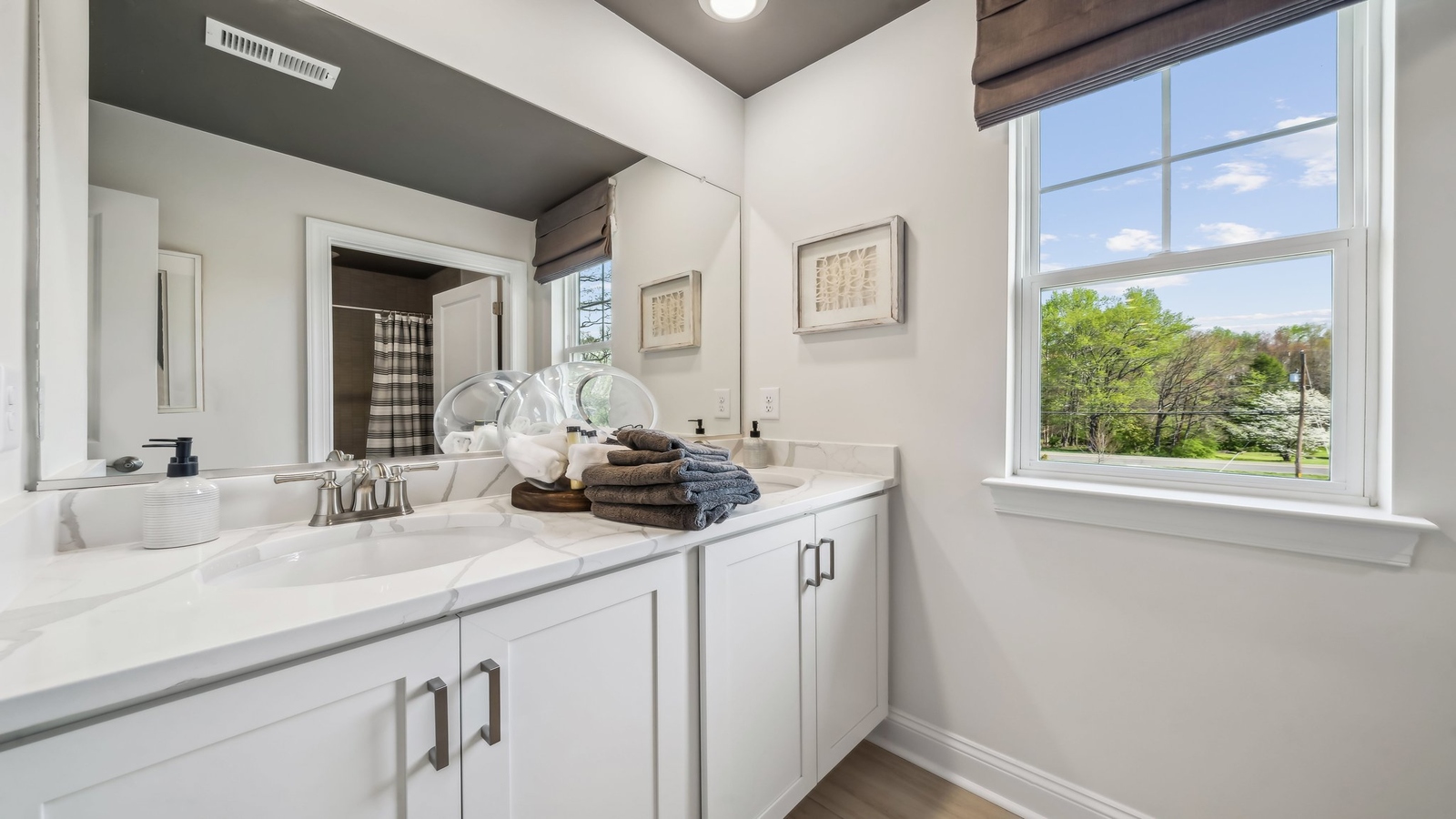 Secondary bathroom adds quality with a combination shower-tub, cabinet storage, vanity, mirror at Red Oaks