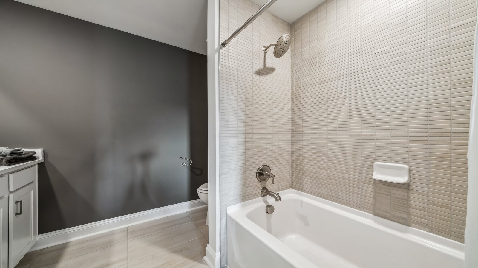 Secondary bathroom adds quality with a combination shower-tub, cabinet storage, vanity, mirror at Red Oaks