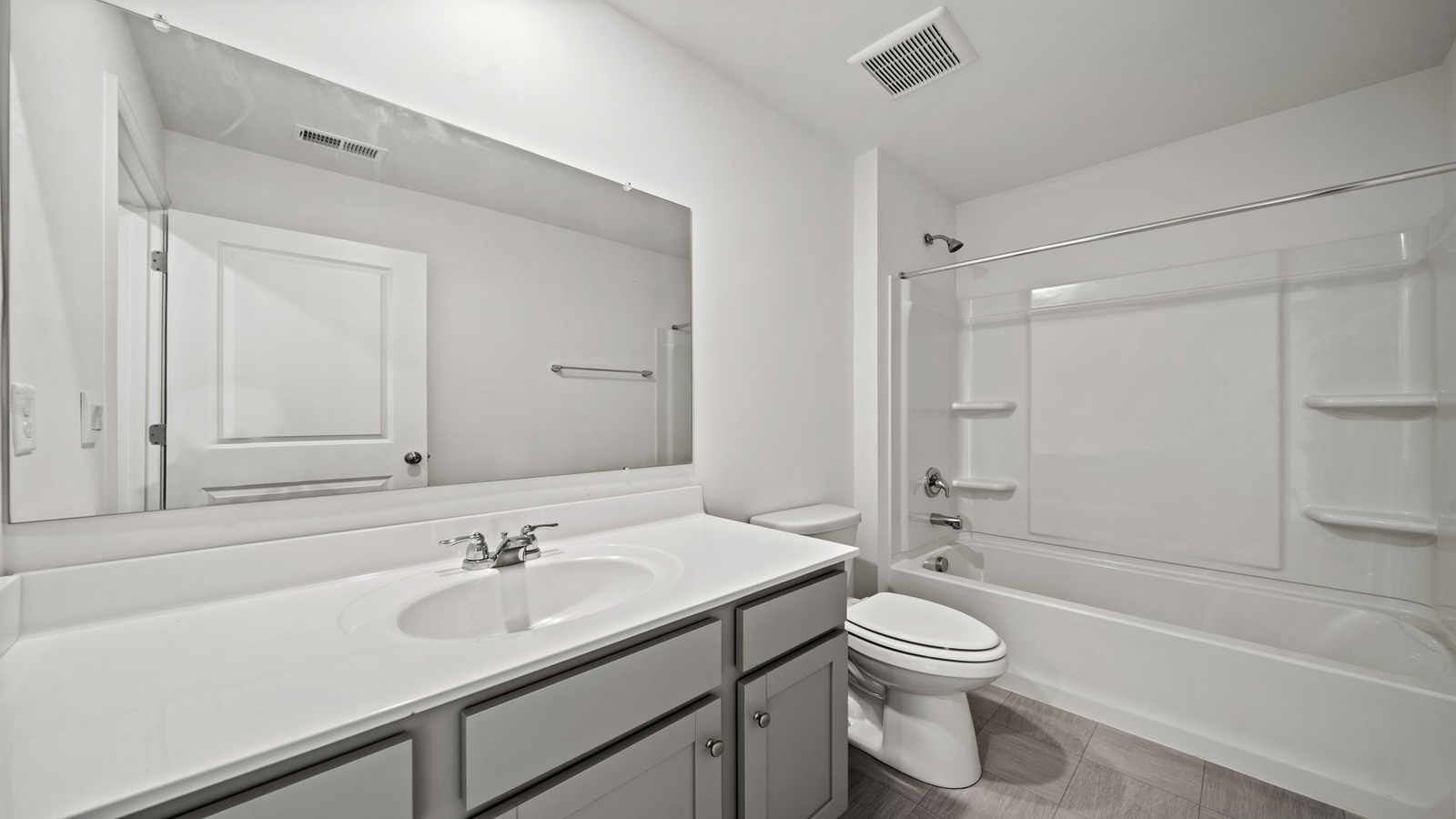 Secondary bathroom adds quality with a combination shower-tub, cabinet storage, vanity, mirror at Chappell Creek