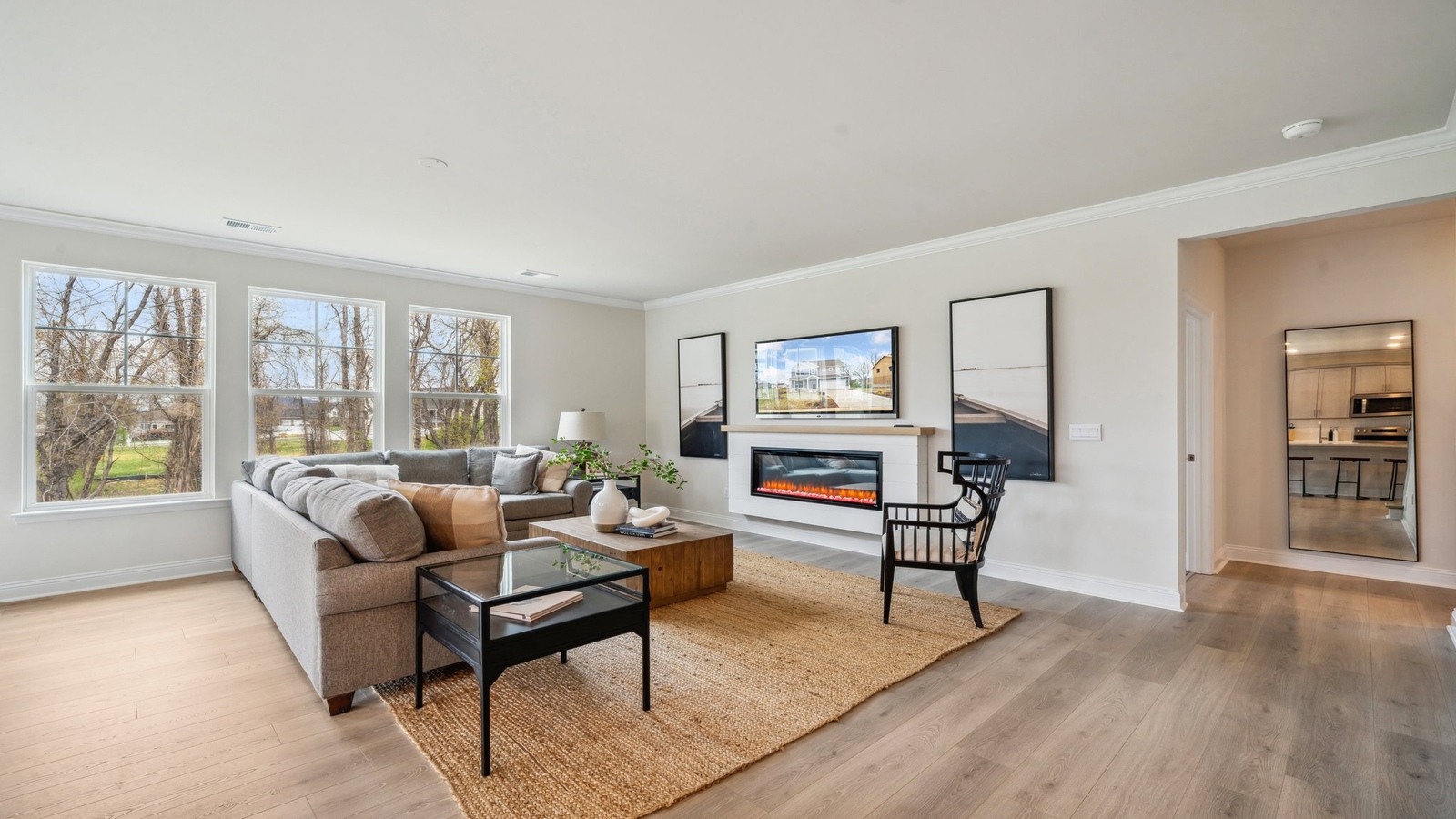 Living room, kitchen, and dining area function as one cohesive main space at Copper Grove at Harpers Mill by D.R. Horton