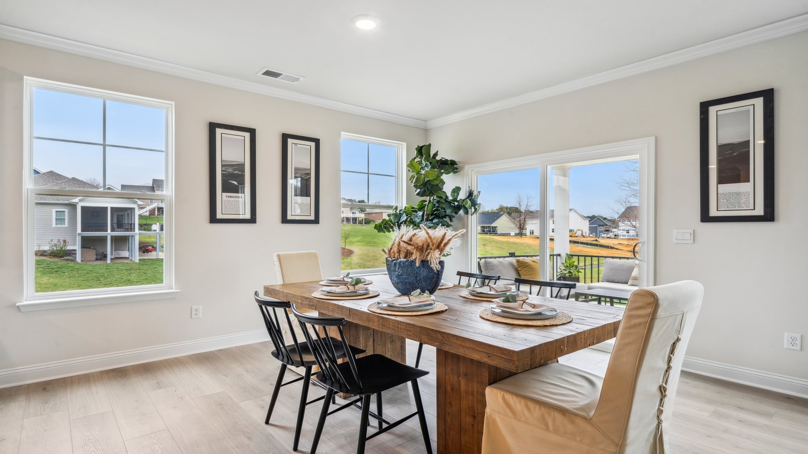 Dining room with electric fireplace, natural light, and seamless flow into kitchen with hard surface island