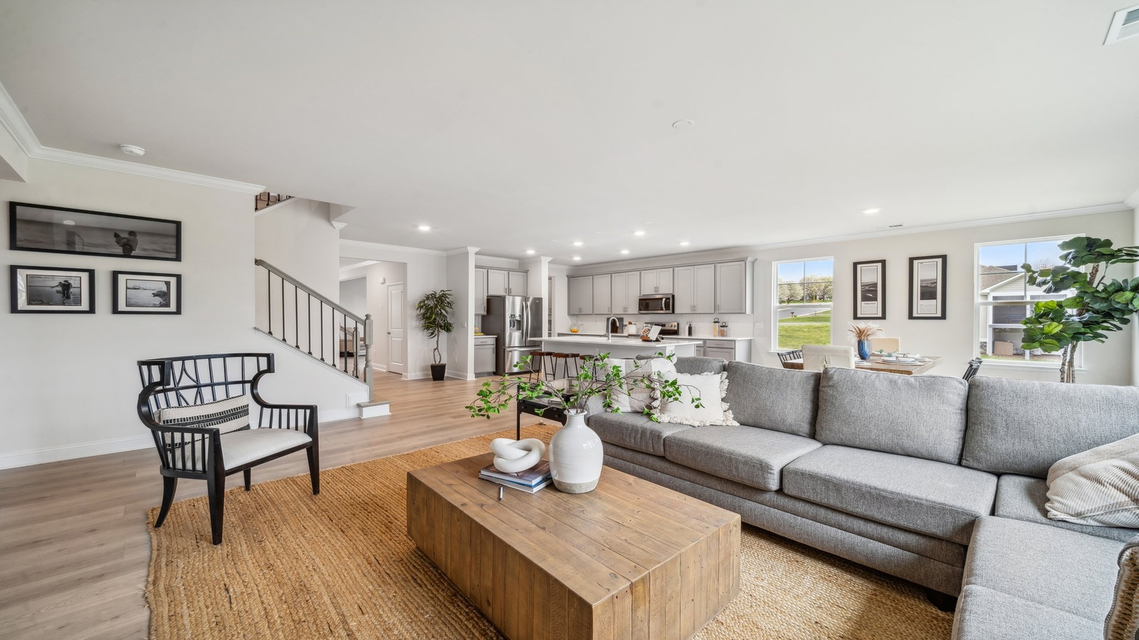 Comfortable main living space with hard surface flooring, connected kitchen and dining areas in Copper Grove at Harpers Mill