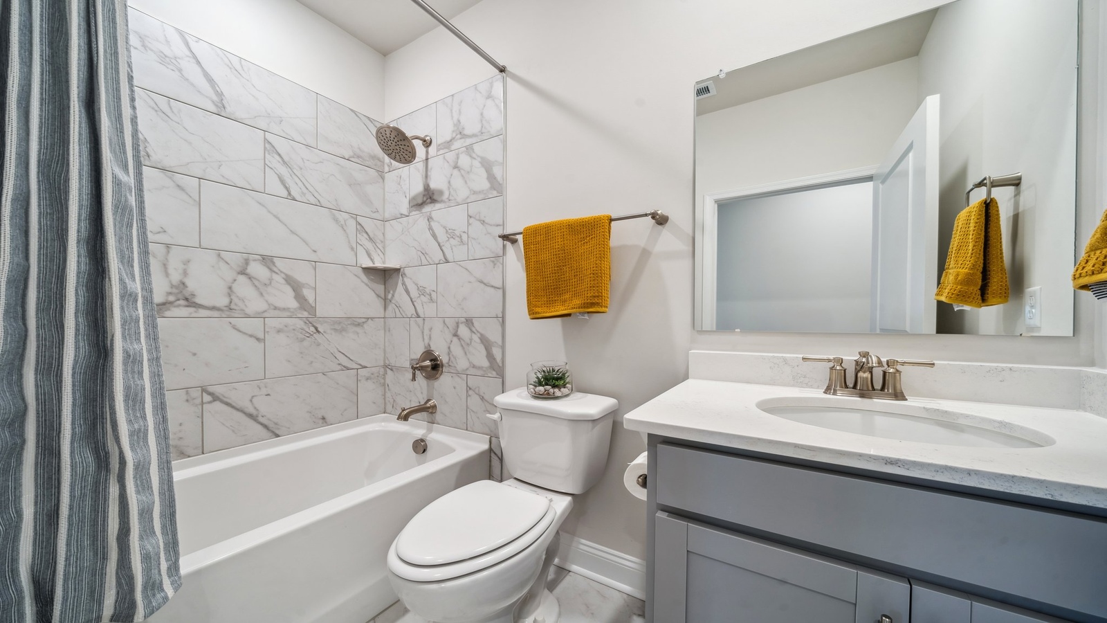 Spacious en-suite bathroom featuring excellent vanity with fixtures, stylish bath-shower finishes and walk-in closet access