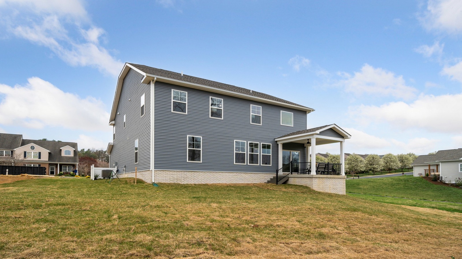 Outdoor living area includes covered rear patio, flat backyard, and rear-facing windows from the main level