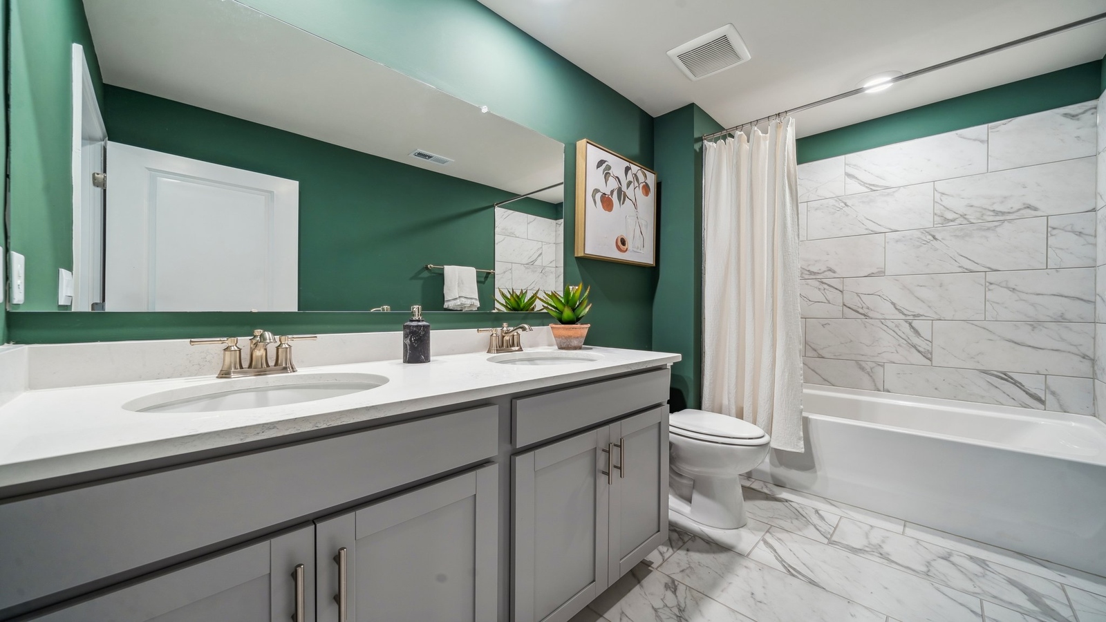 Family bathroom with decorative shower curtain and transom window above the tub in Copper Grove at Harpers Mill