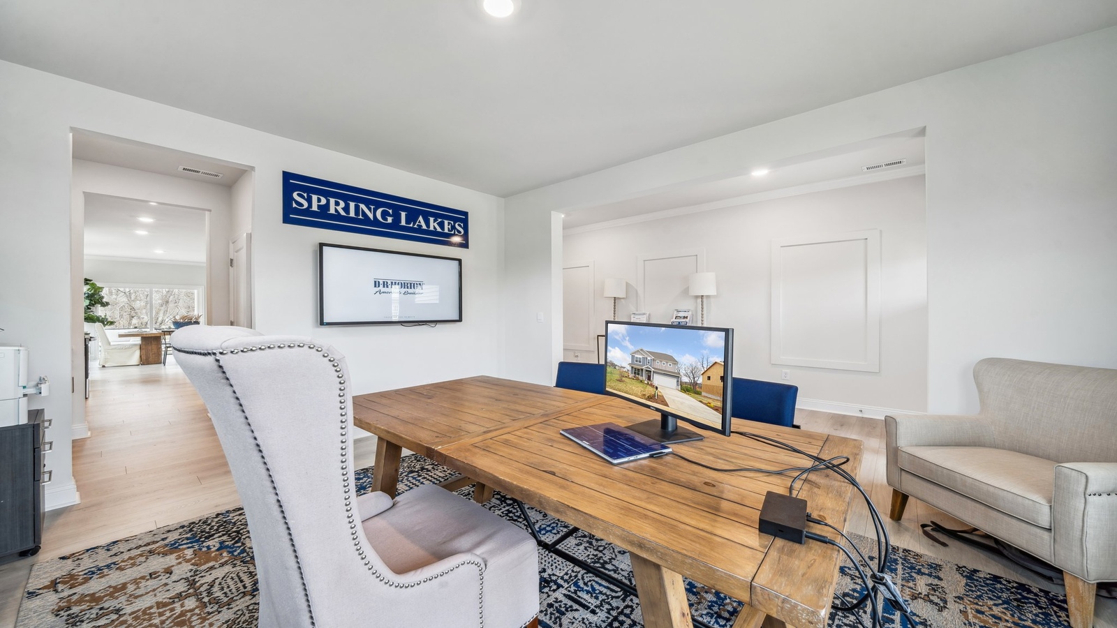 Family room with stylish flooring leading to kitchen and upstair access in Copper Grove at Harpers Mill