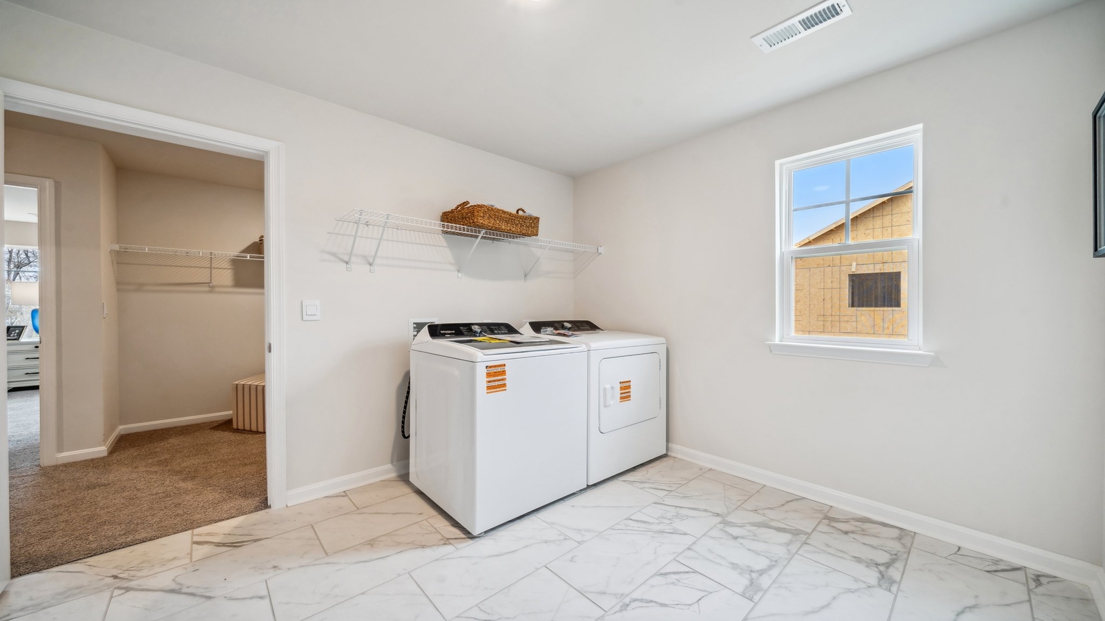 Modern laundry room in Copper Grove at Harpers Mill with smart upper shelving and clean finishes