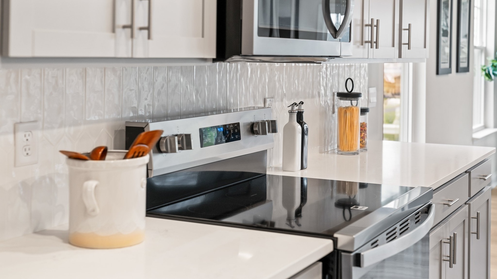 Modern kitchen and dining area showcases an oversized island, bar seating and new appliance suite layout.