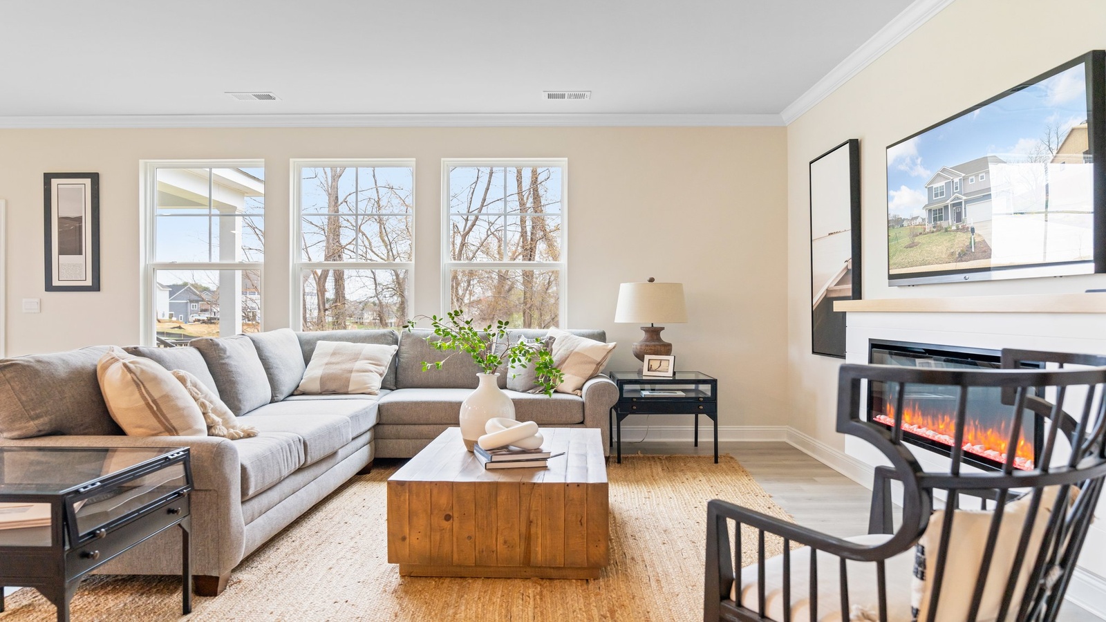 Main-level living room offers a bright space with simple lines, electric fireplace, Open Concept connections