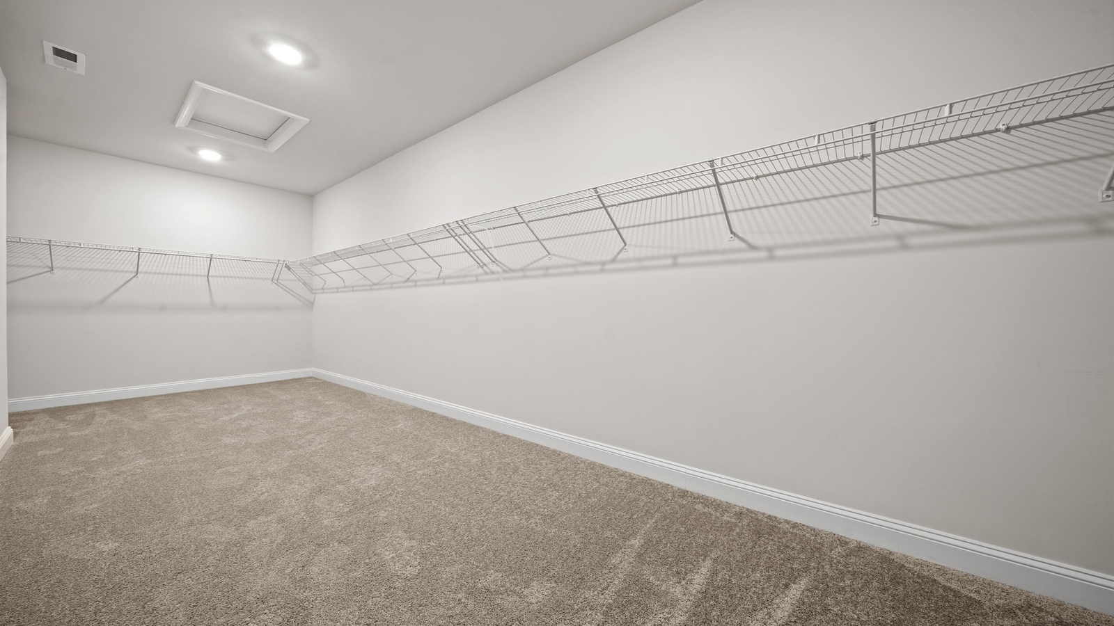 Primary bedroom walk-in closet enjoys ample space for clothes and accessories in Copper Grove at Harpers Mill