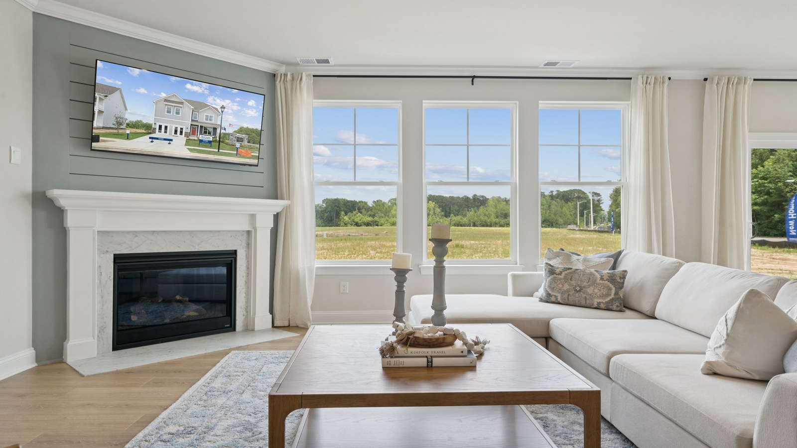 Main living area in Copper Grove at Harpers Mill with electric fireplace for flow between dining, kitchen, and family room