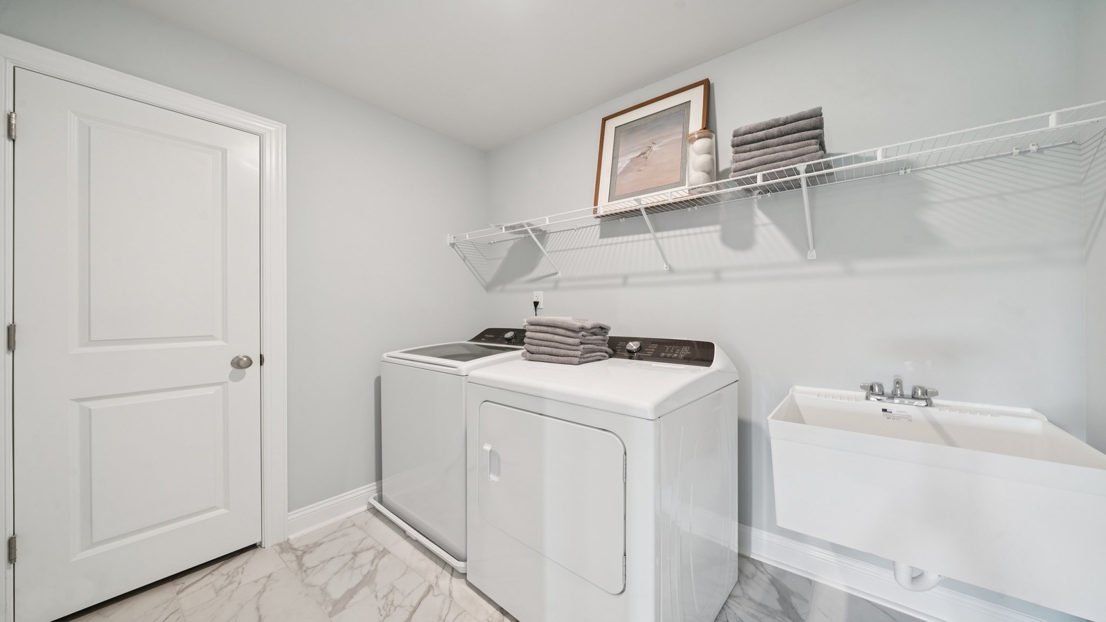 Convenient utility laundry layout in Copper Grove at Harpers Mill featuring a new washer-dryer area, crafty elevated storage
