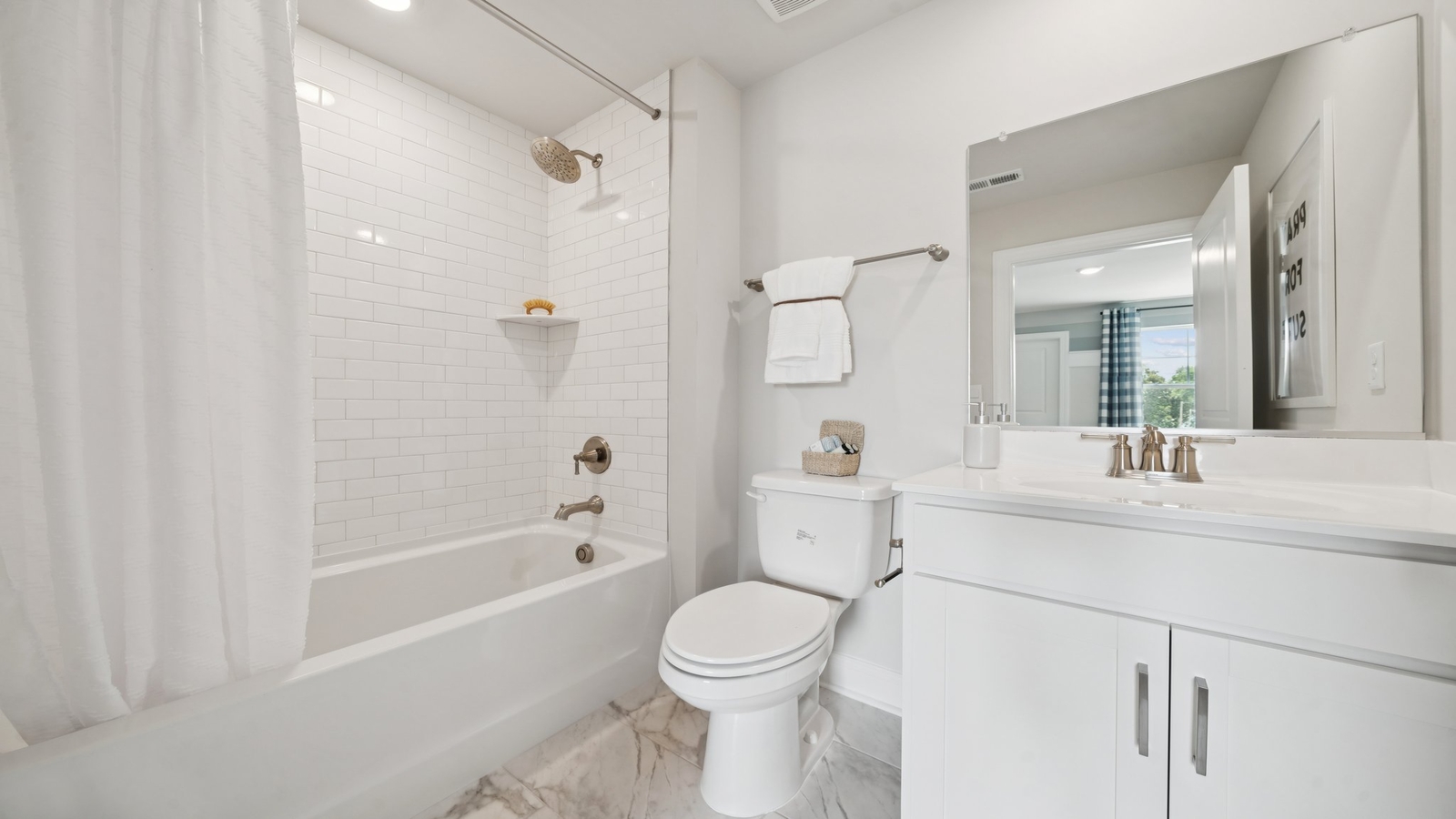 Family shower-bath, modern cabinetry, chrome faucet, hard surface counter at Copper Grove at Harpers Mill by D.R. Horton