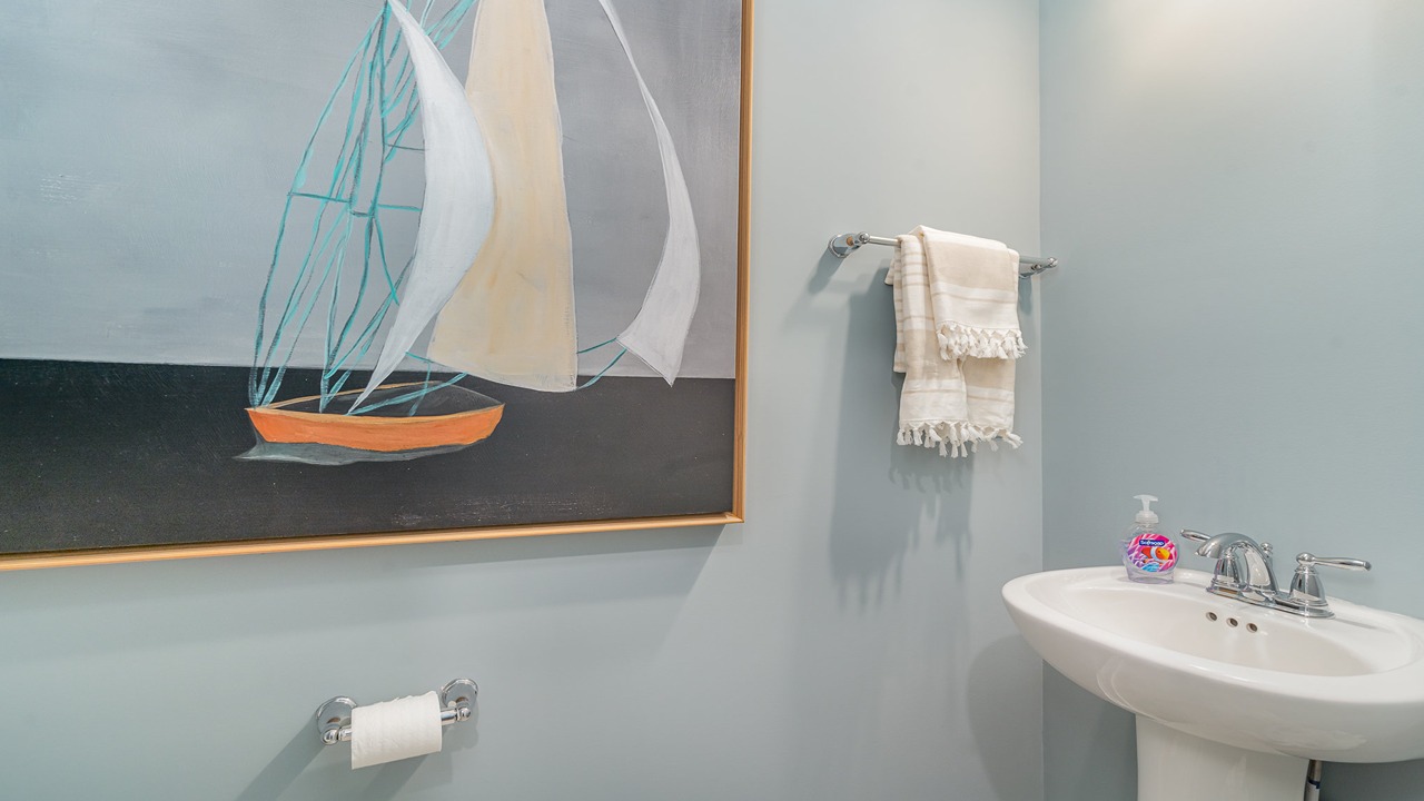 Half bath with door open to hallway, pedestal sink visible with silver faucet in Copper Grove at Harpers Mill