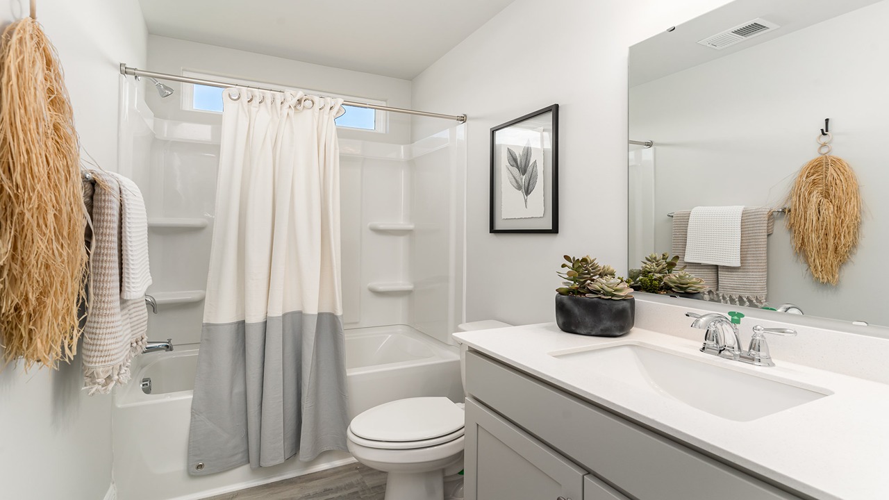 Primary bathroom in this New Build Home includes extended vanity, quality cabinets, walk-in closet and spa-style layout