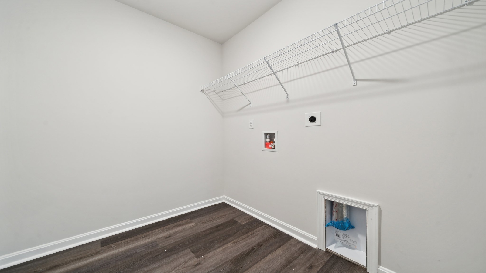 Modern laundry room in Brewers Meadows South with smart upper shelving and clean finishes, storage options
