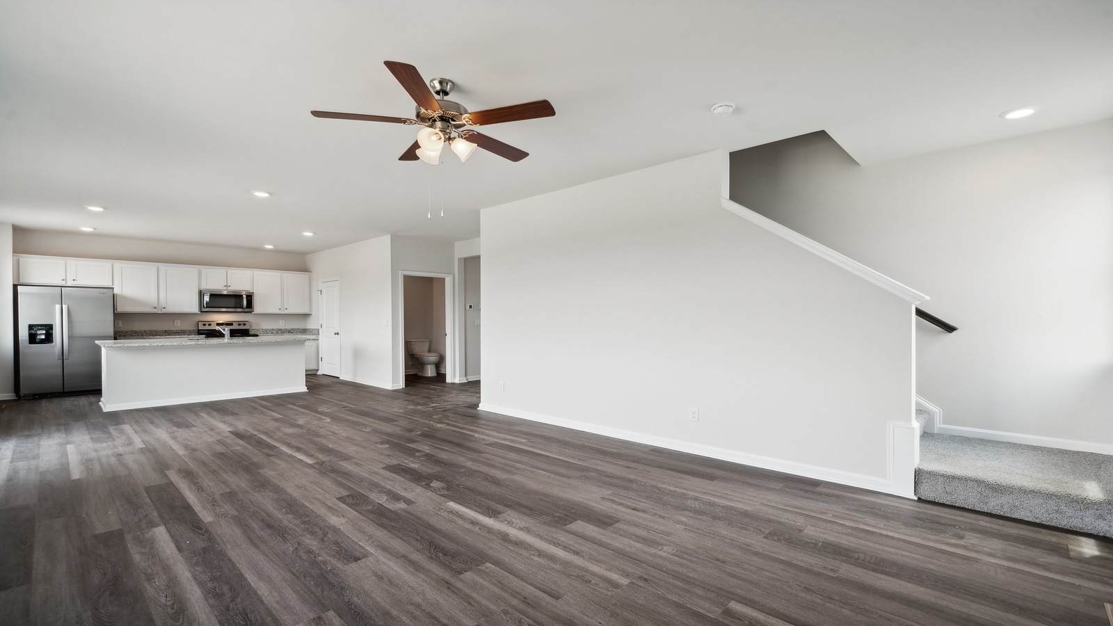 Main-level living room offers a bright space, an electric fireplace, and Main Level Open Concept connections to stairs