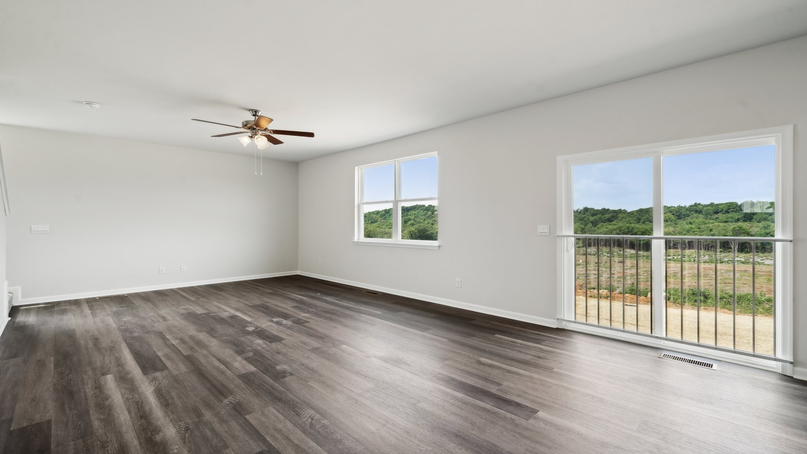 Living room designed by D.R. Horton showcases central access to the rear patio, kitchen and bedrooms