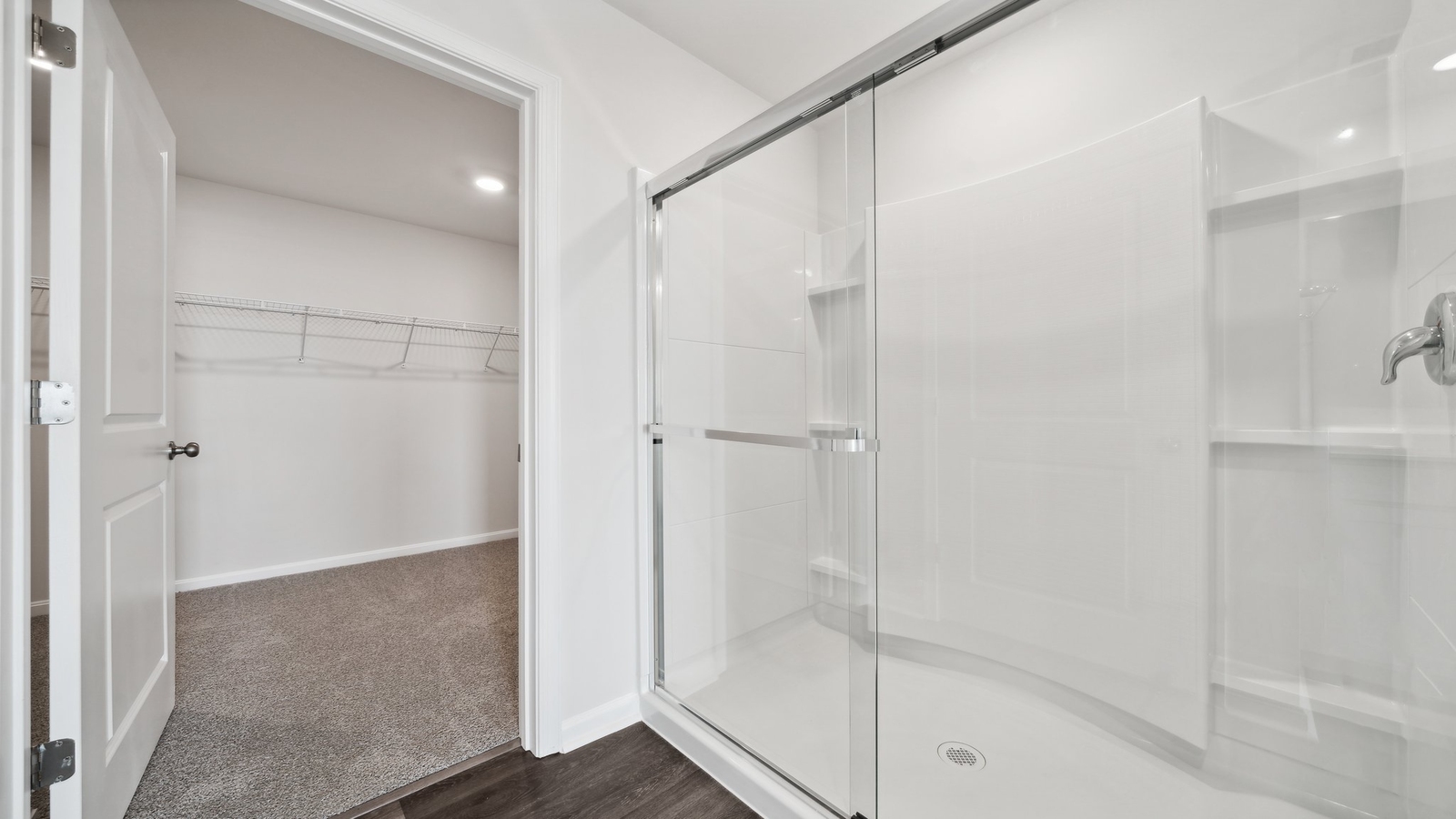 Primary bathroom in this New Build Home includes extended vanity, quality cabinets, walk-in closet and spa-inspired design