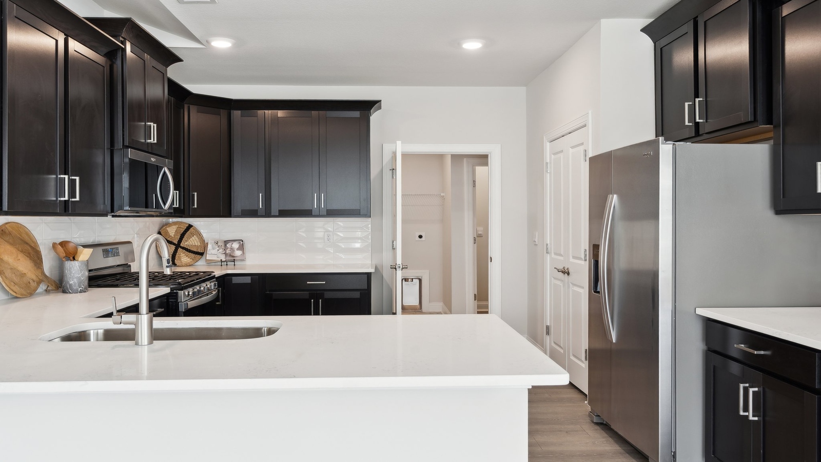 Kitchen island in D.R. Horton layout connects dining and living areas with efficient flow and modern surface finishes