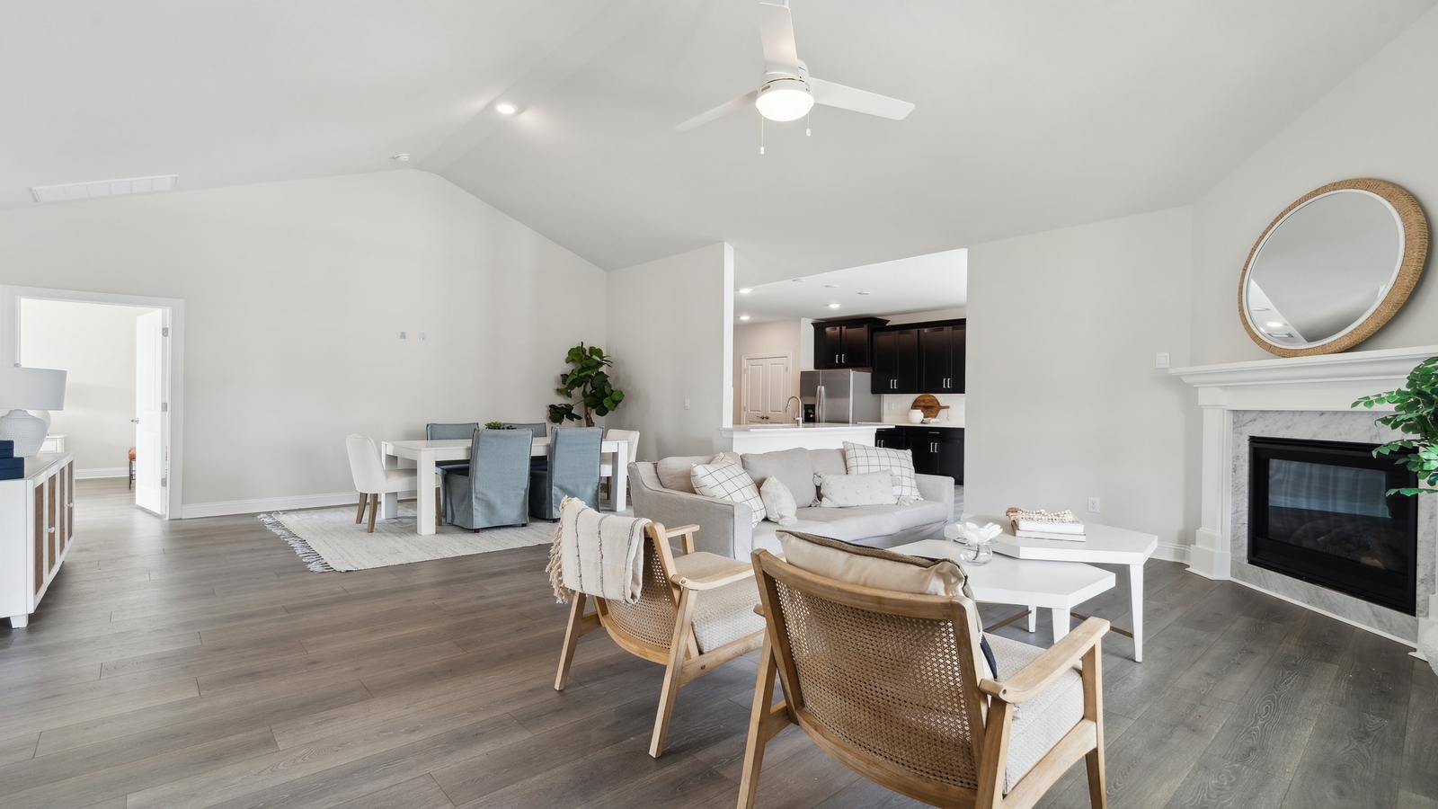 Living area facing kitchen with new appliances, cabinetry options, pantry, and stairway upstairs in Retreat at Edinburgh Farms