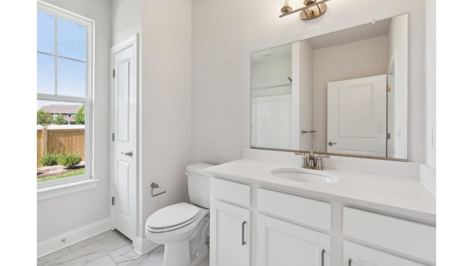 Family shower-bath, modern cabinetry, chrome faucet, storage options at Retreat at Edinburgh Farms by D.R. Horton