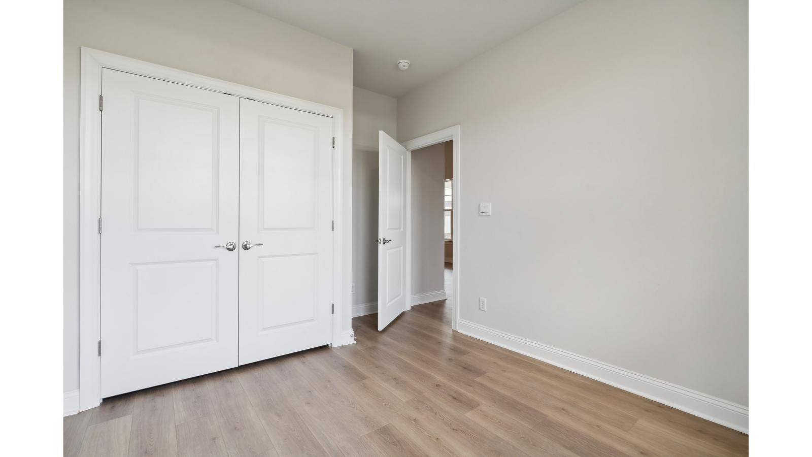 Primary bedroom designed for privacy and space with clean lines and a convenient flow into en-suite bathroom and walk-in closet