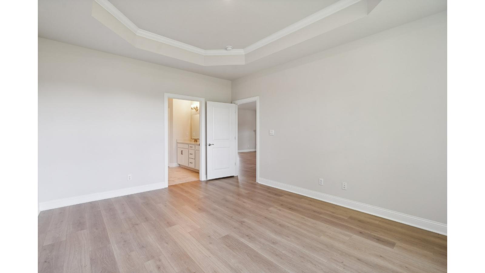 Bright and open primary bedroom in Retreat at Edinburgh Farms with walk-in closet, en-suite bath, large window overlooking backyard.