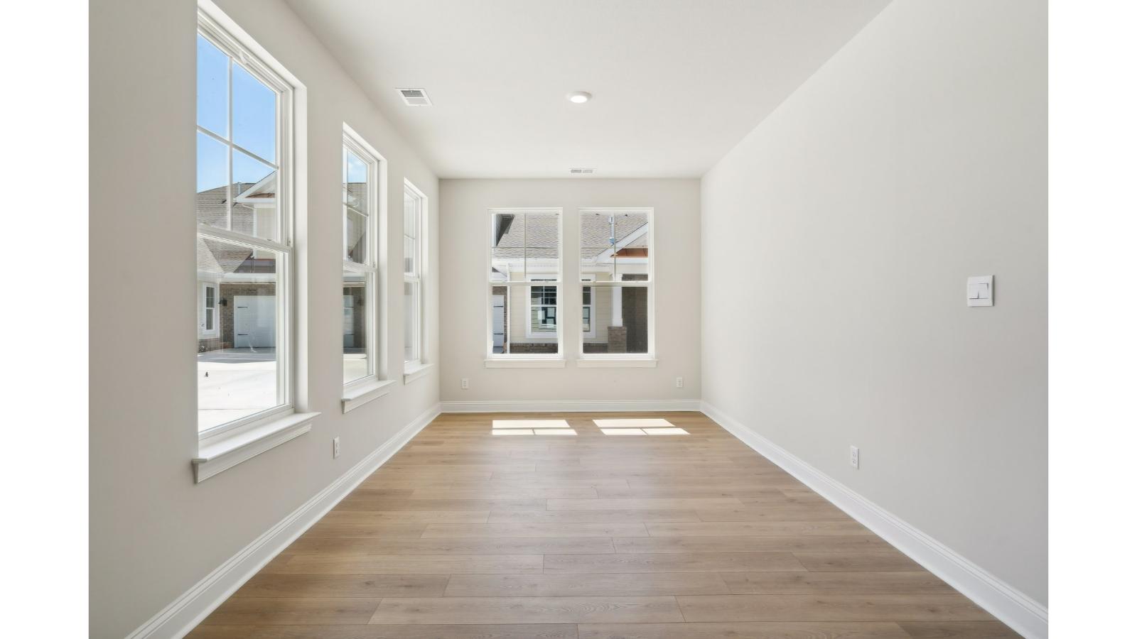Sun room with stylish flooring, connected kitchen with stairwell view at Retreat at Edinburgh Farms