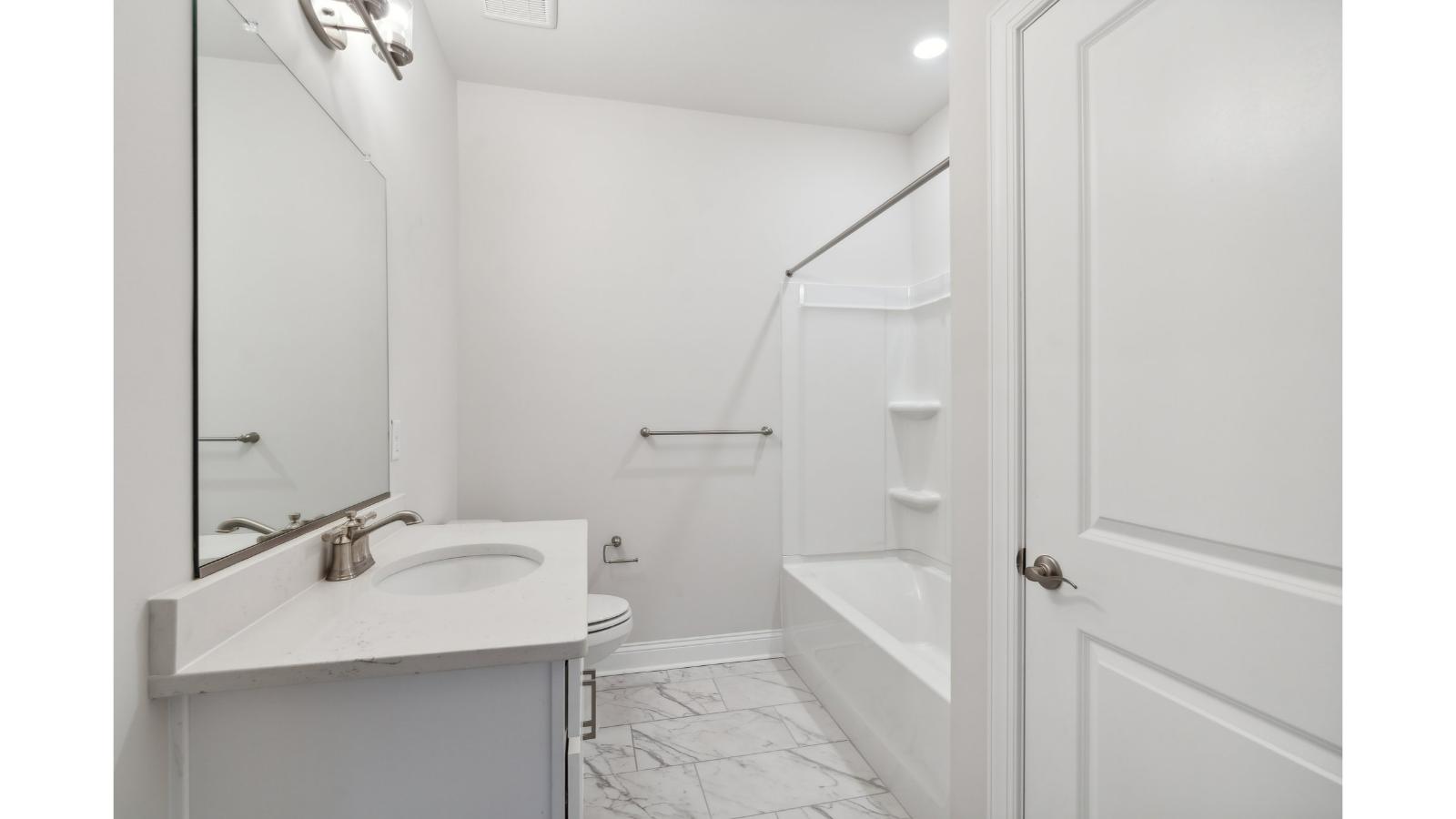 Family bathroom with decorative tile, storage, tub-shower combo in Retreat at Edinburgh Farms