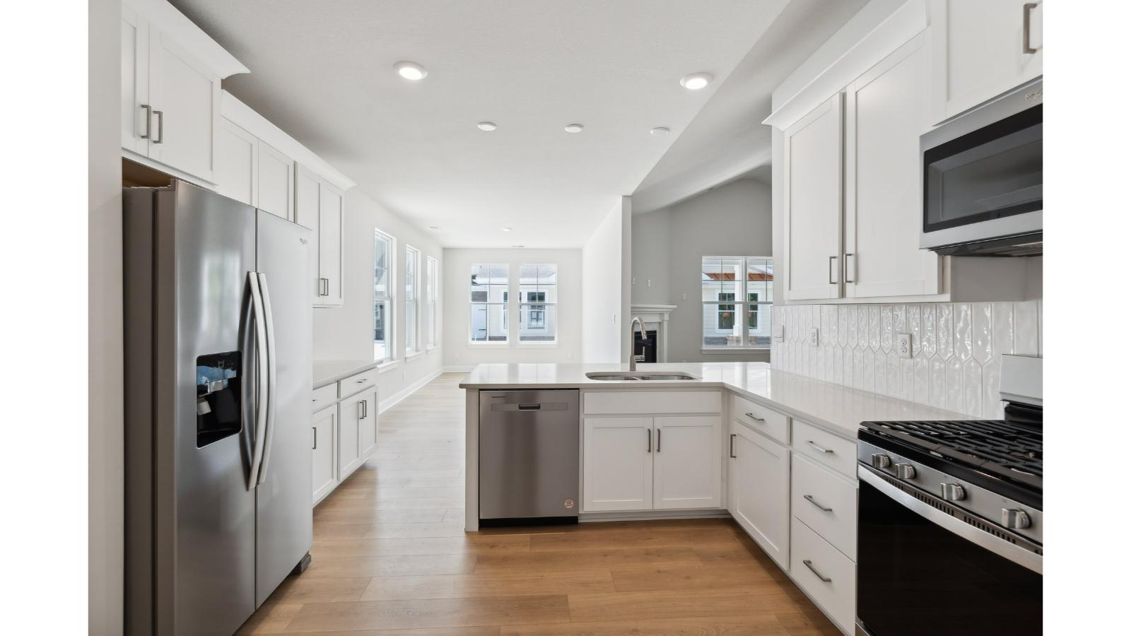 Contemporary kitchen with a walk-in pantry, island with seating, new appliance suite in Retreat at Edinburgh Farms