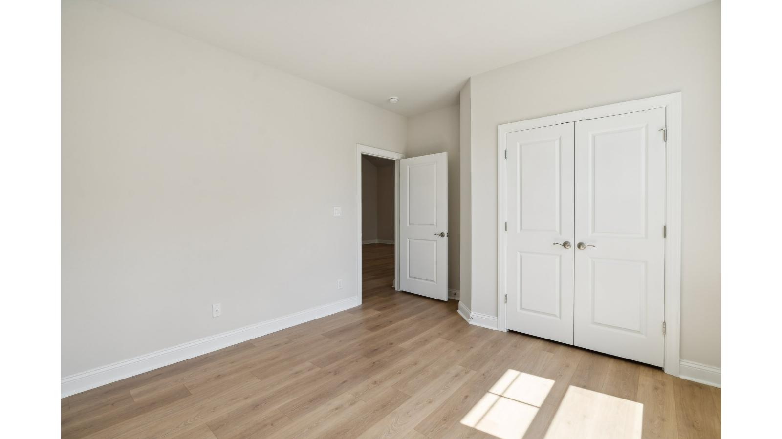 Owner’s suite offers natural window light, a spa-inspired en-suite bathroom, and a walk-in closet for everyday comfort