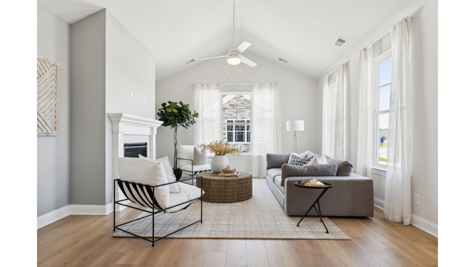 Main-level living room offers a bright space, electric fireplace, Open Concept connections throughout