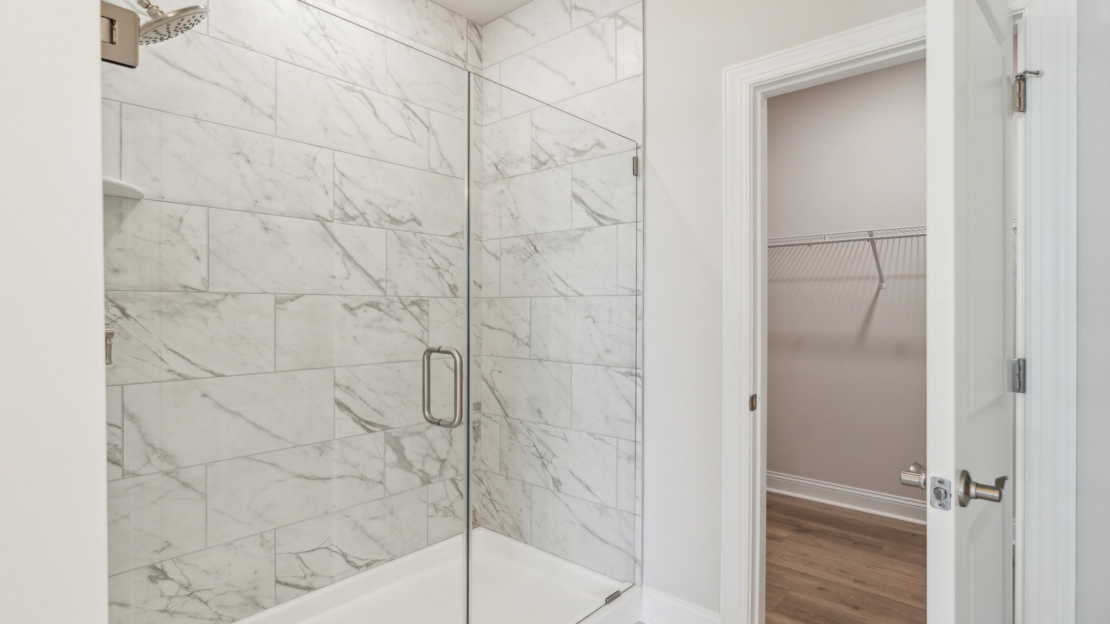 Spacious ensuite bathroom featuring excellent vanity with fixtures, stylish bath-shower finishes and walk-in closet access