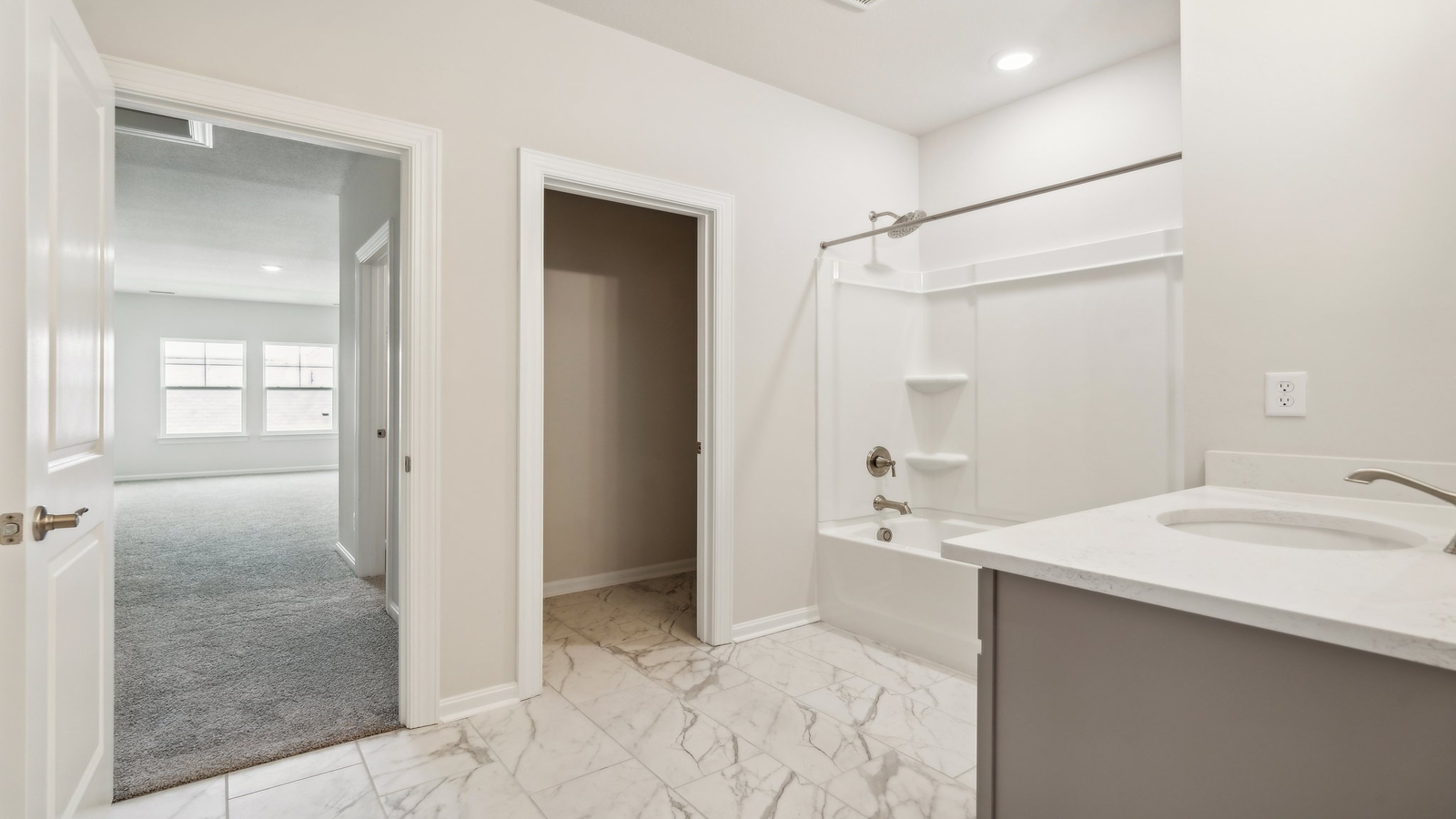 Full bathroom at Retreat at Edinburgh Farms with built-in tub and shower combo, vanity lighting, and framed mirror