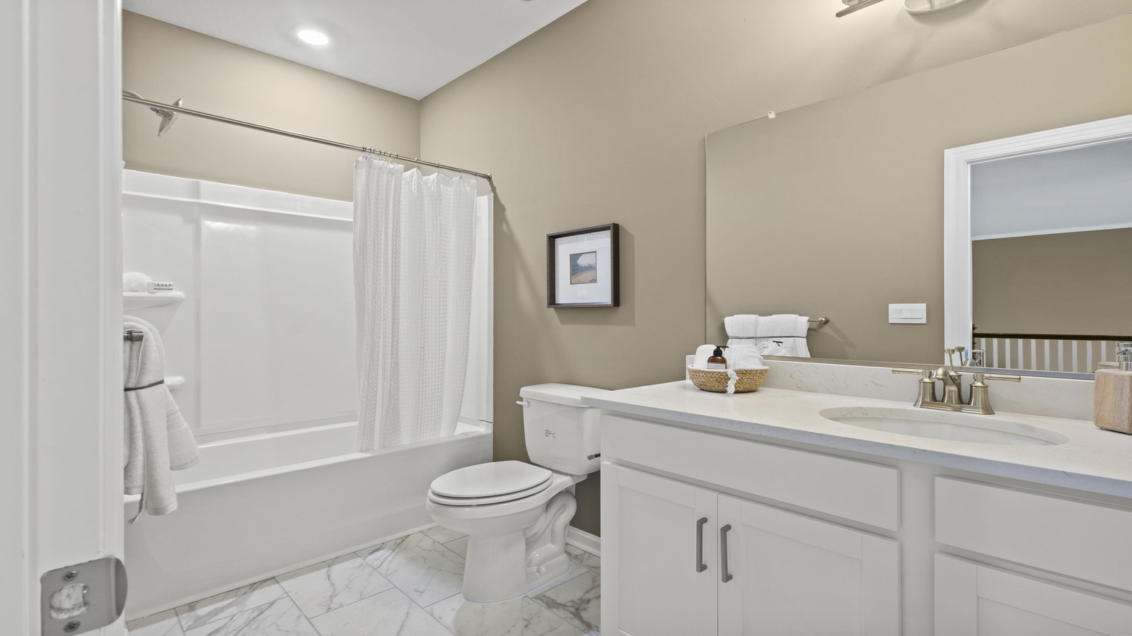 Family bathroom with decorative tile, storage, tub-shower combo in Retreat at Edinburgh Farms