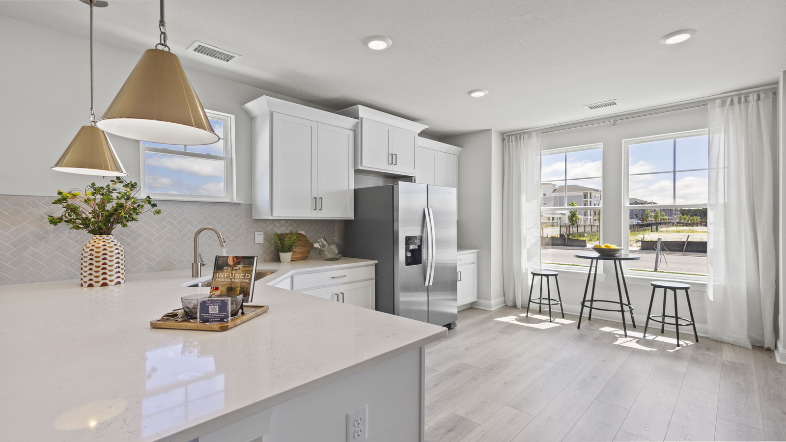 Kitchen island in this D.R. Horton New Home featuring seating, storage, pantry and a New appliance suite