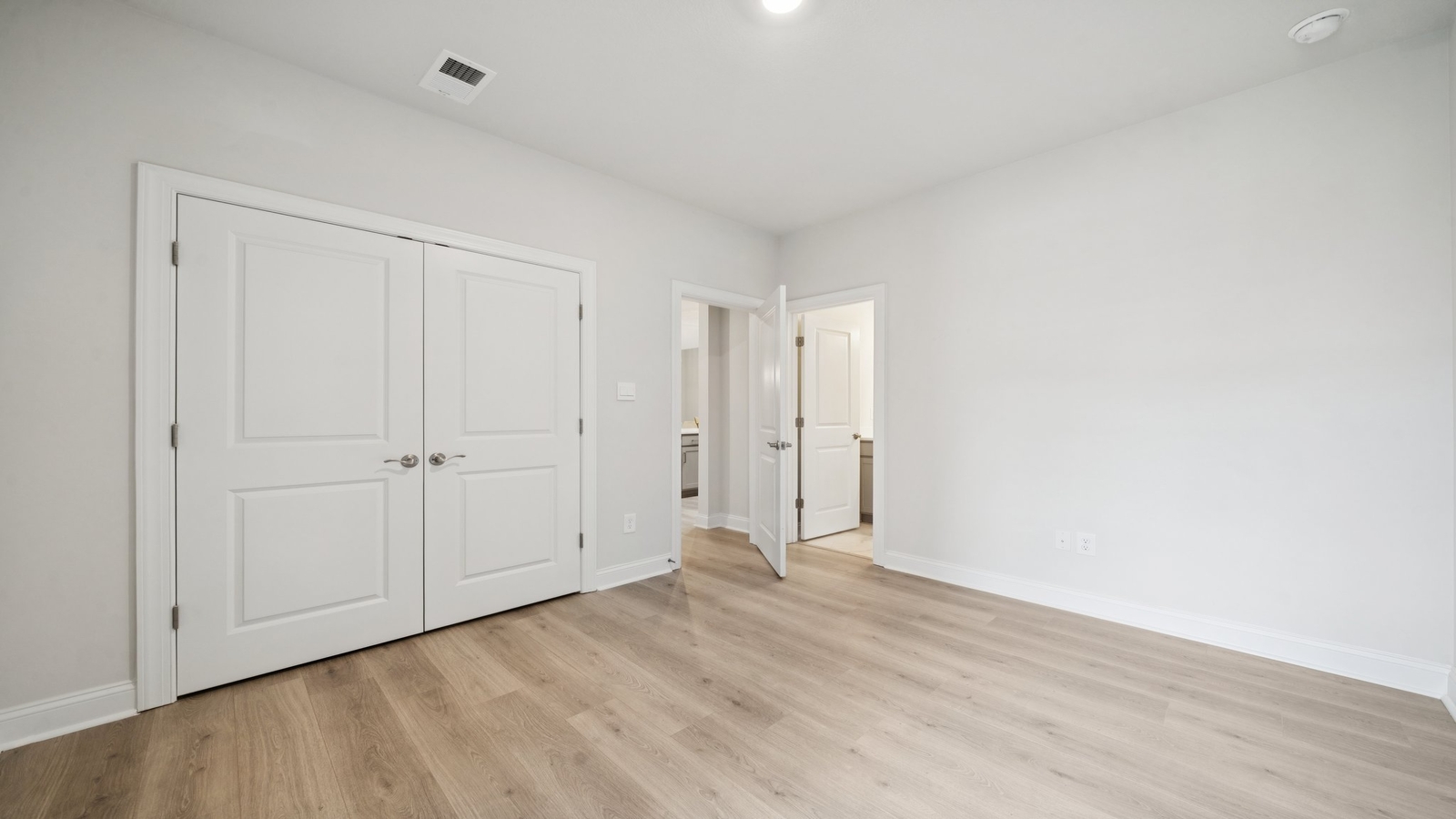 Primary bedroom designed for privacy and space with clean lines and a convenient flow into en-suite bathroom and walk-in closet