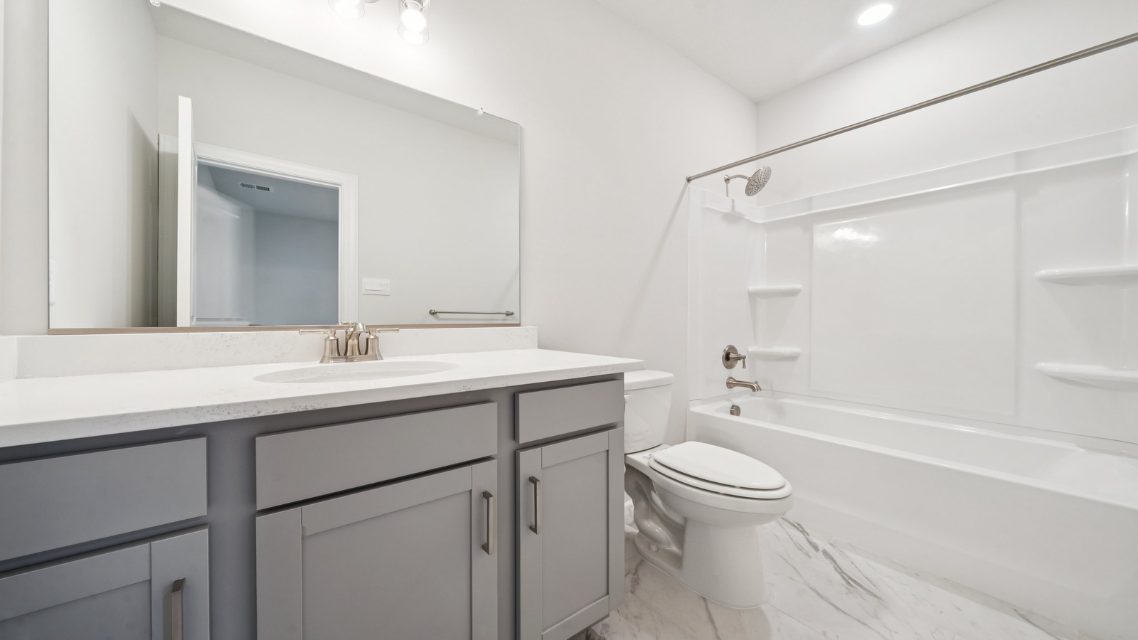 Primary bathroom in this New Build Home includes extended vanity, quality cabinets, walk-in closet and spa-style layout