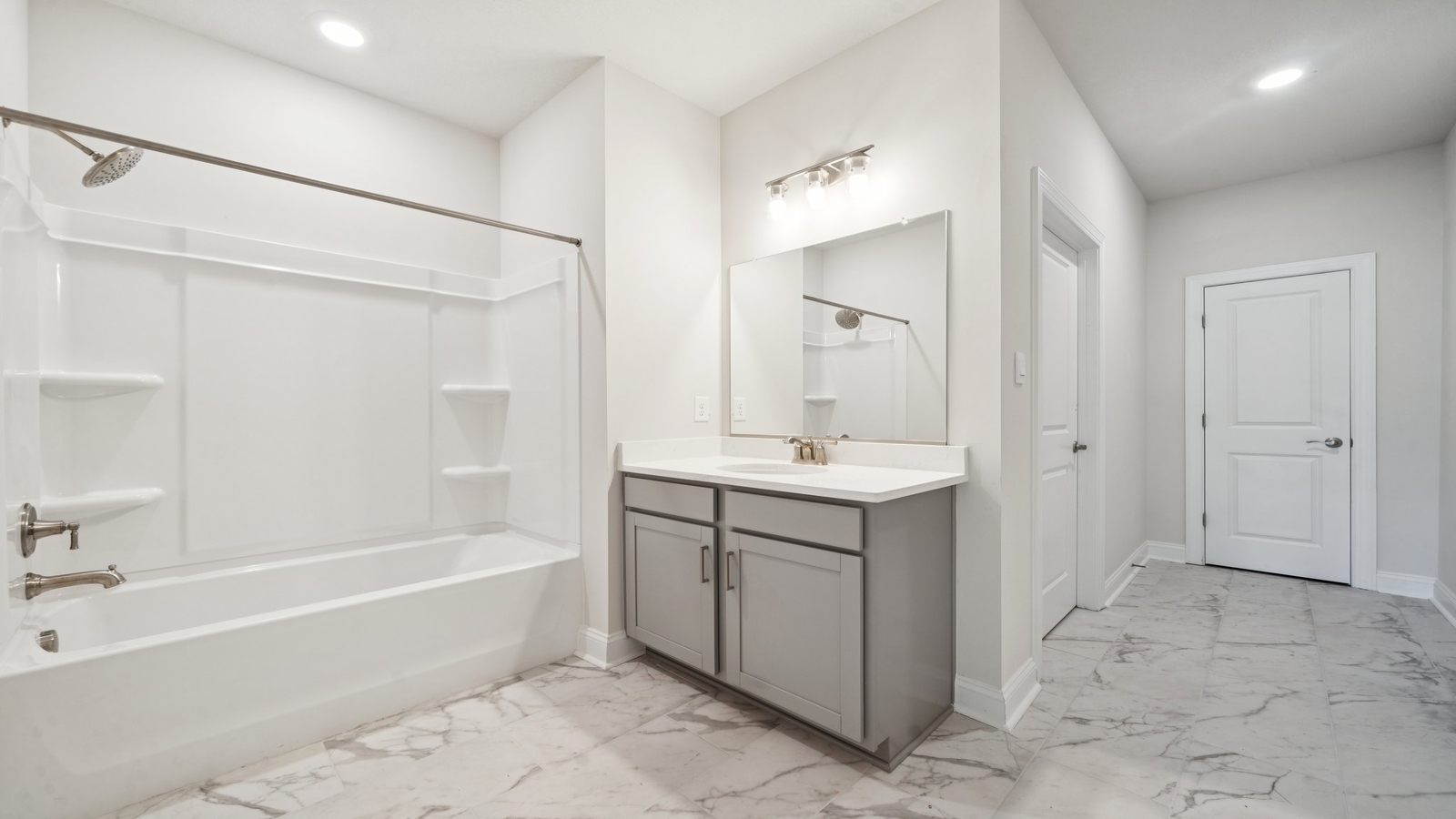 New Home showcases a D.R. Horton ensuite bathroom with sleek flooring, open layout to shower-tub, and walk-in closet