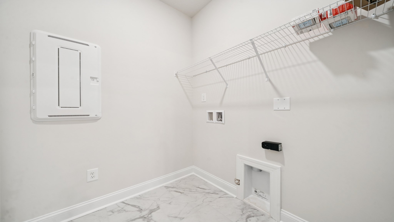 Modern laundry room in Country Club Villas with smart upper shelving and clean finishes