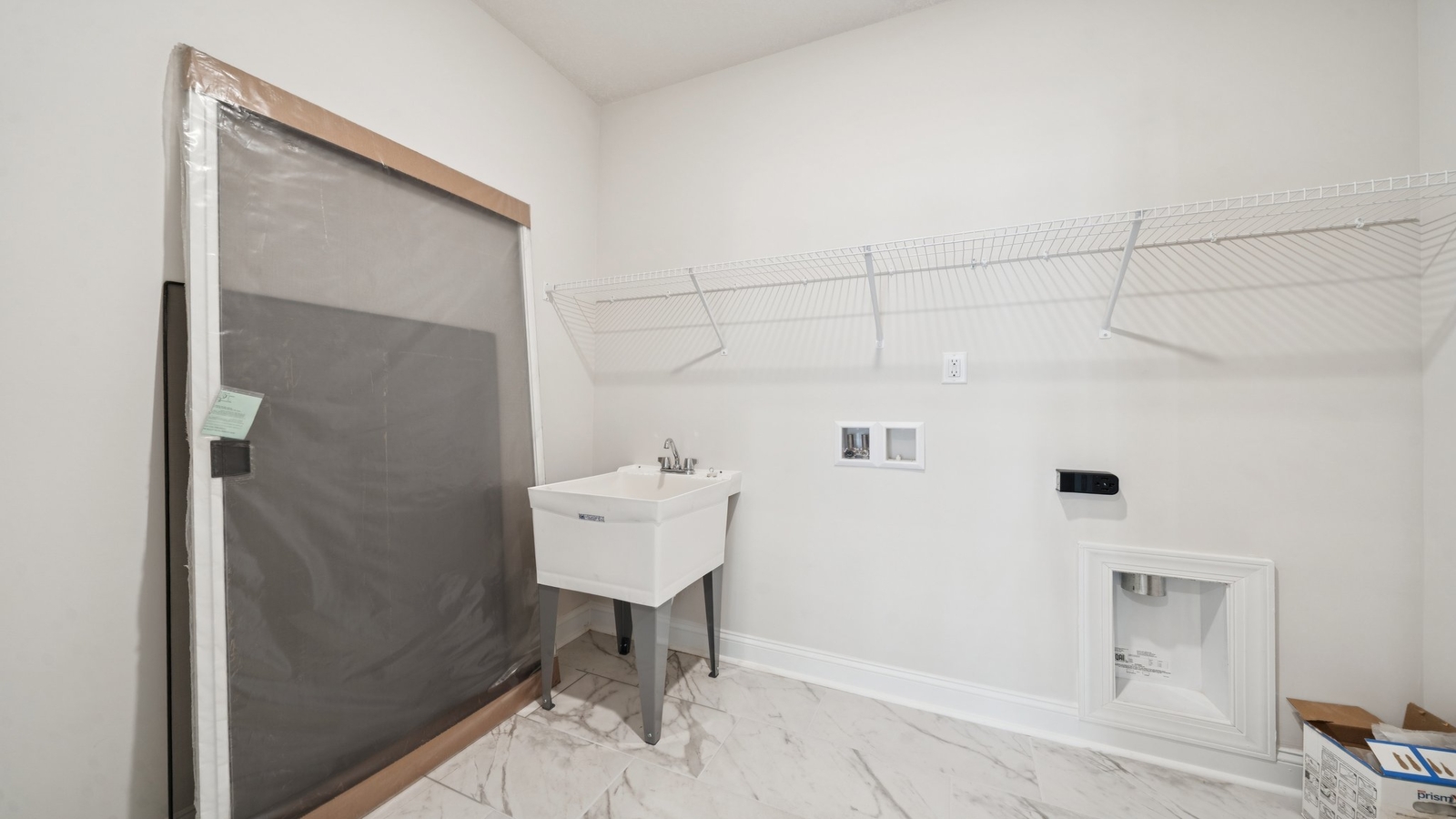 Modern laundry room in Country Club Villas with smart upper shelving and clean finishes