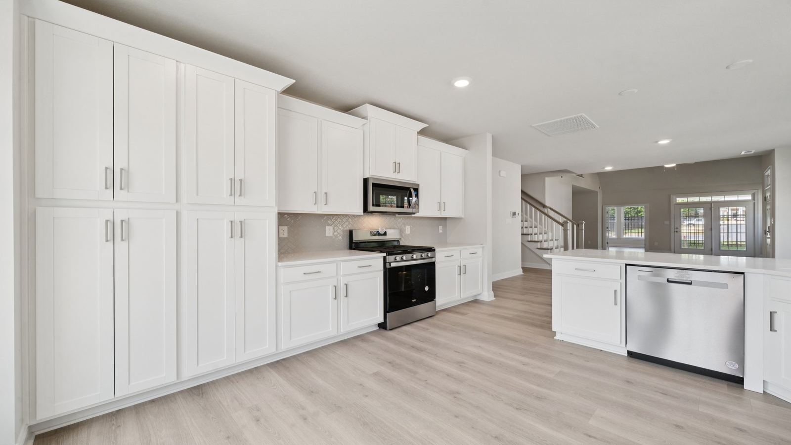 Kitchen-dining-family room blend together with quality flooring, access to dining nook-living areas, and backyard views in New Home