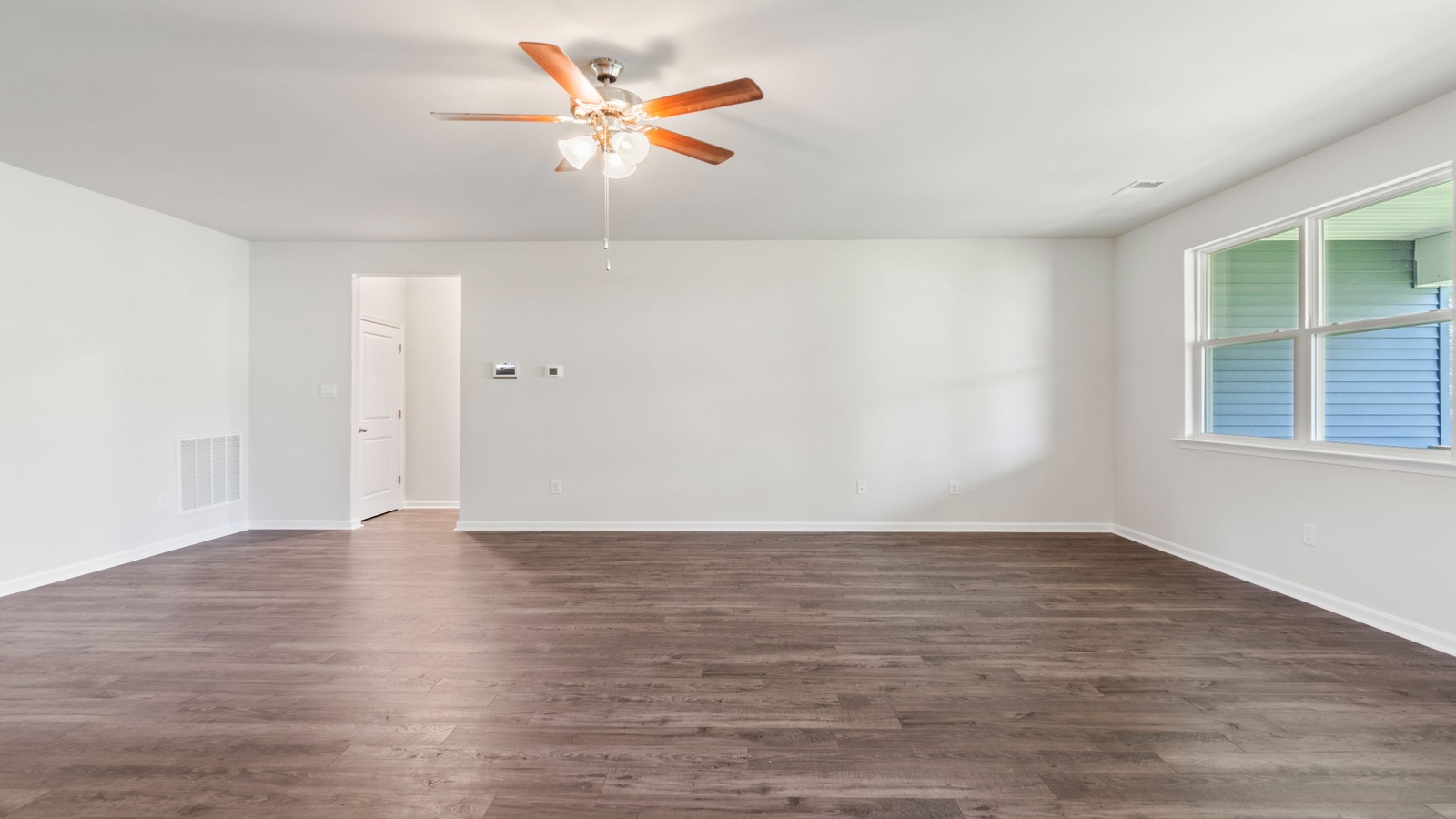 Main living zone with easy access near kitchen, dining area, and an electric fireplace in Riverview Landing