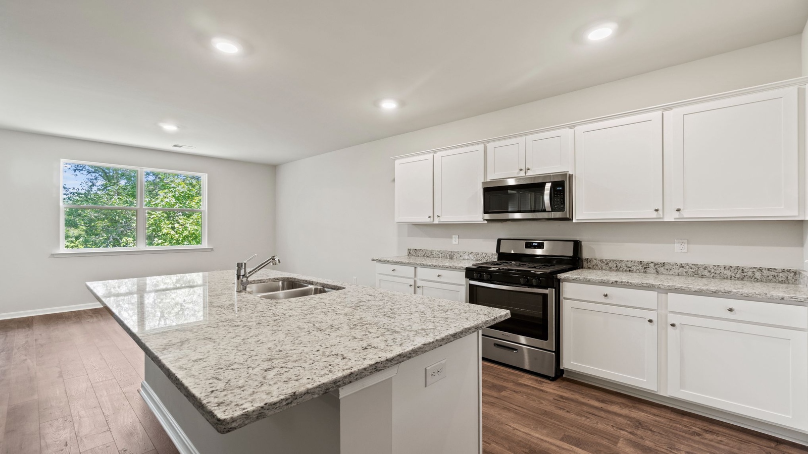 Kitchen island in D.R. Horton layout connects dining and living areas with efficient flow and modern surface finishes